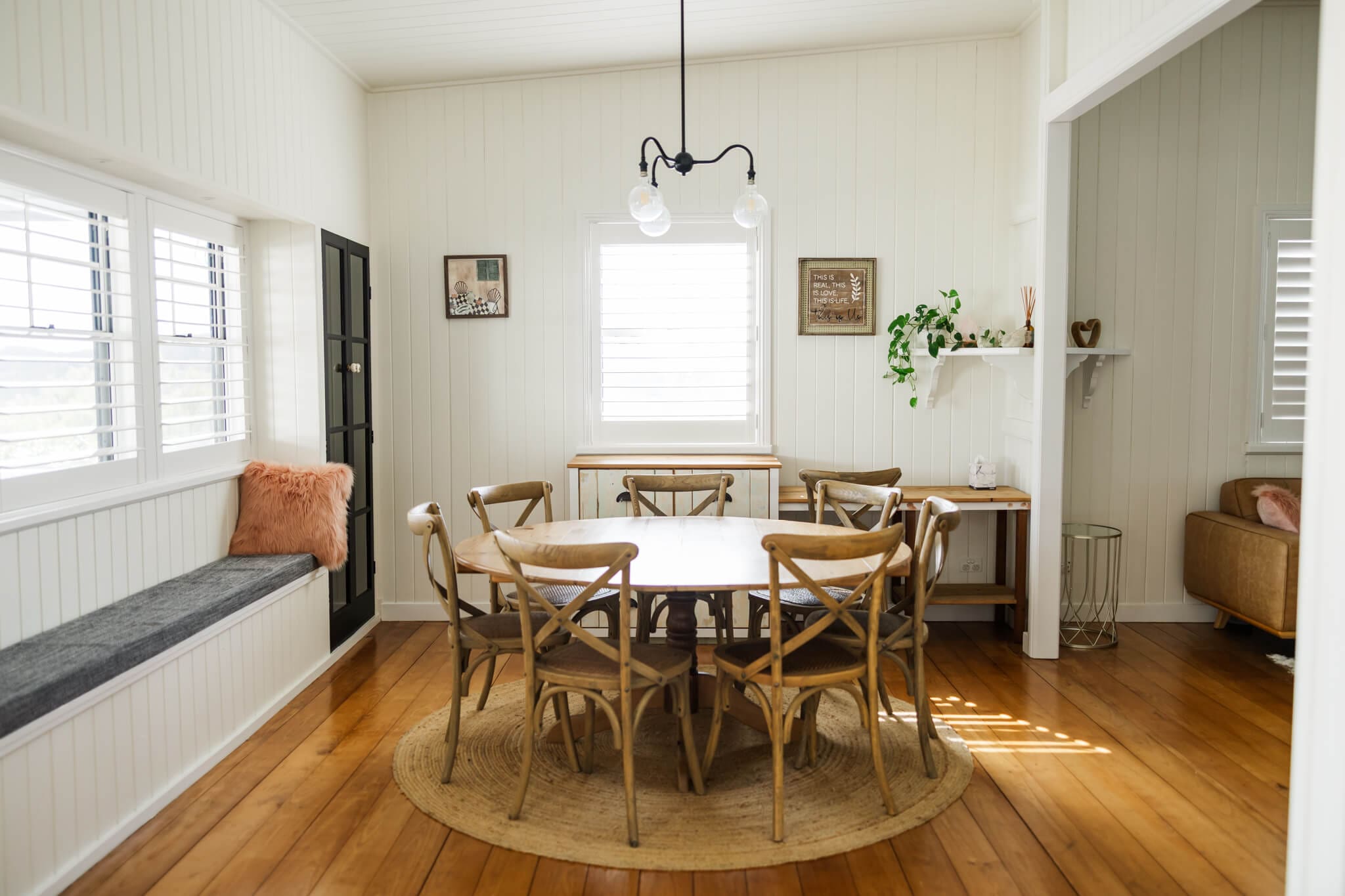 Dining area set out with a wooden table and wooden chairs inside the Farmhouse at Ambrym Estate. Captured by Julie-Anne Photography.