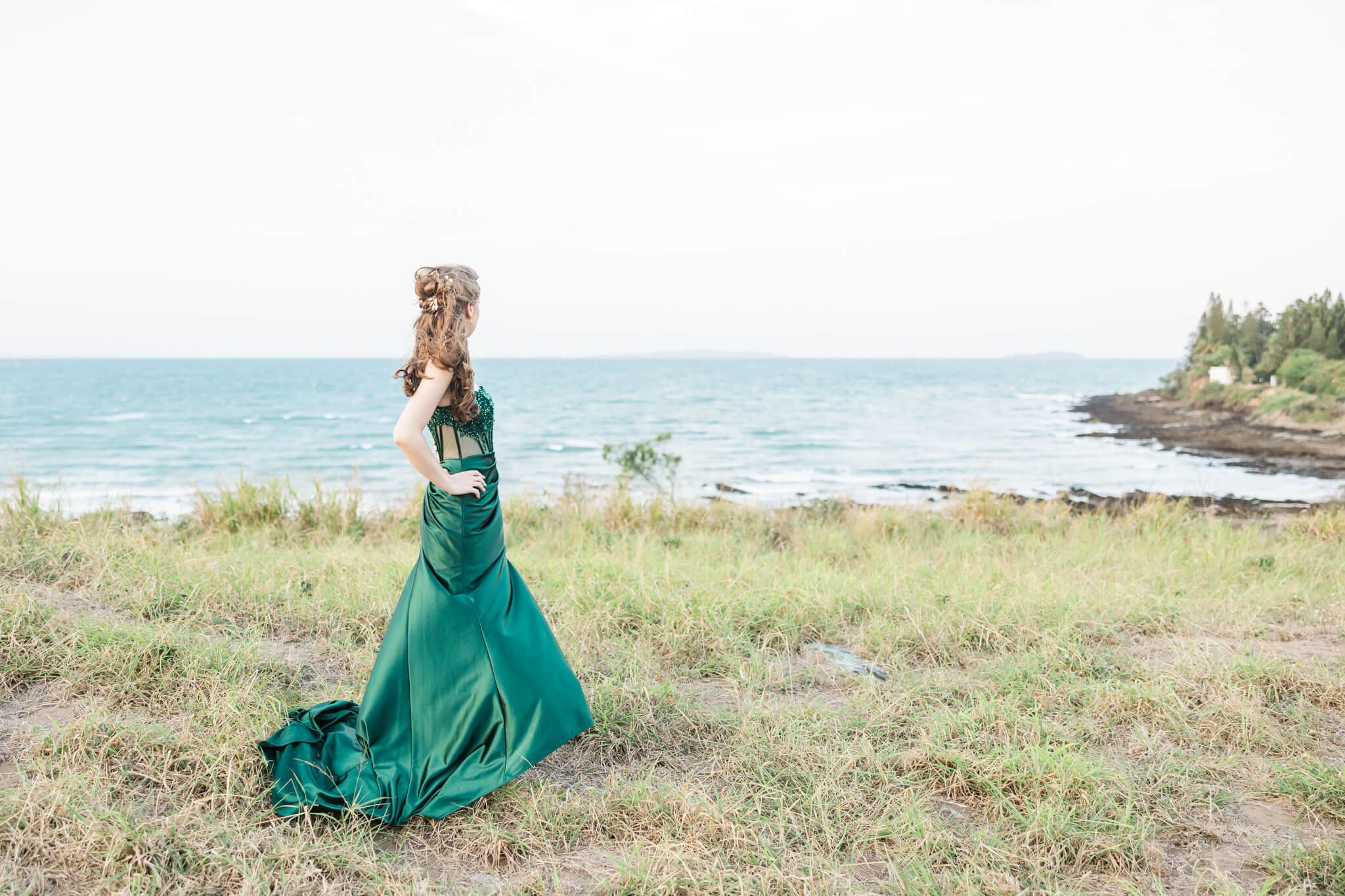Stunning formal photo of a girl in a green dress, posing near the ocean at Emu Park, Queensland