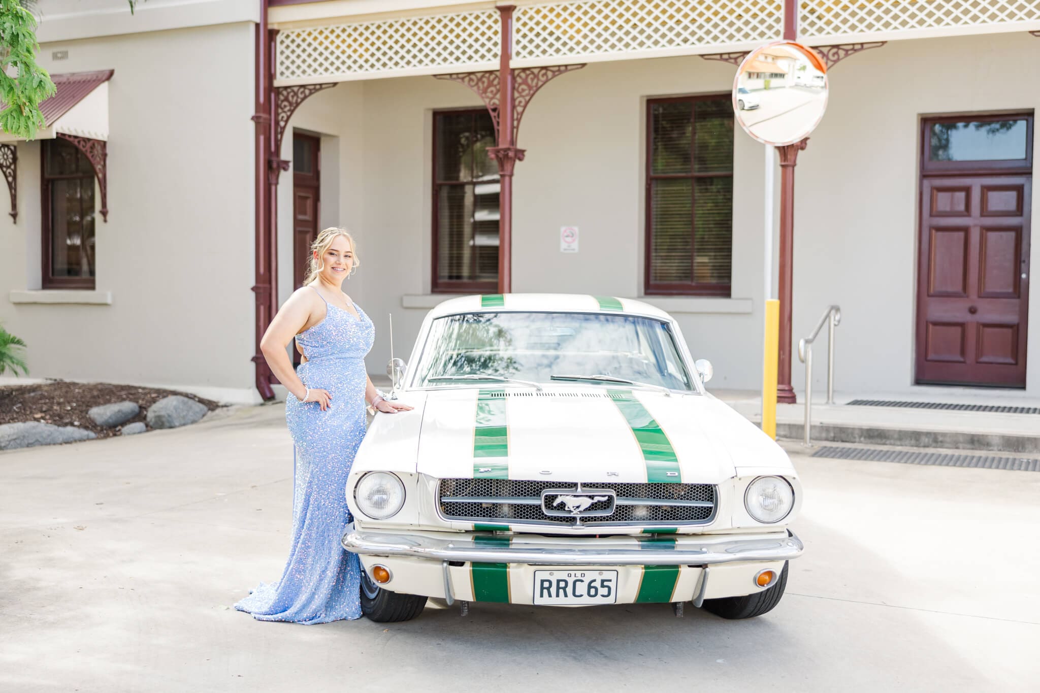 Beautiful photo of girl standing near a cream vintage car for her formal session.
