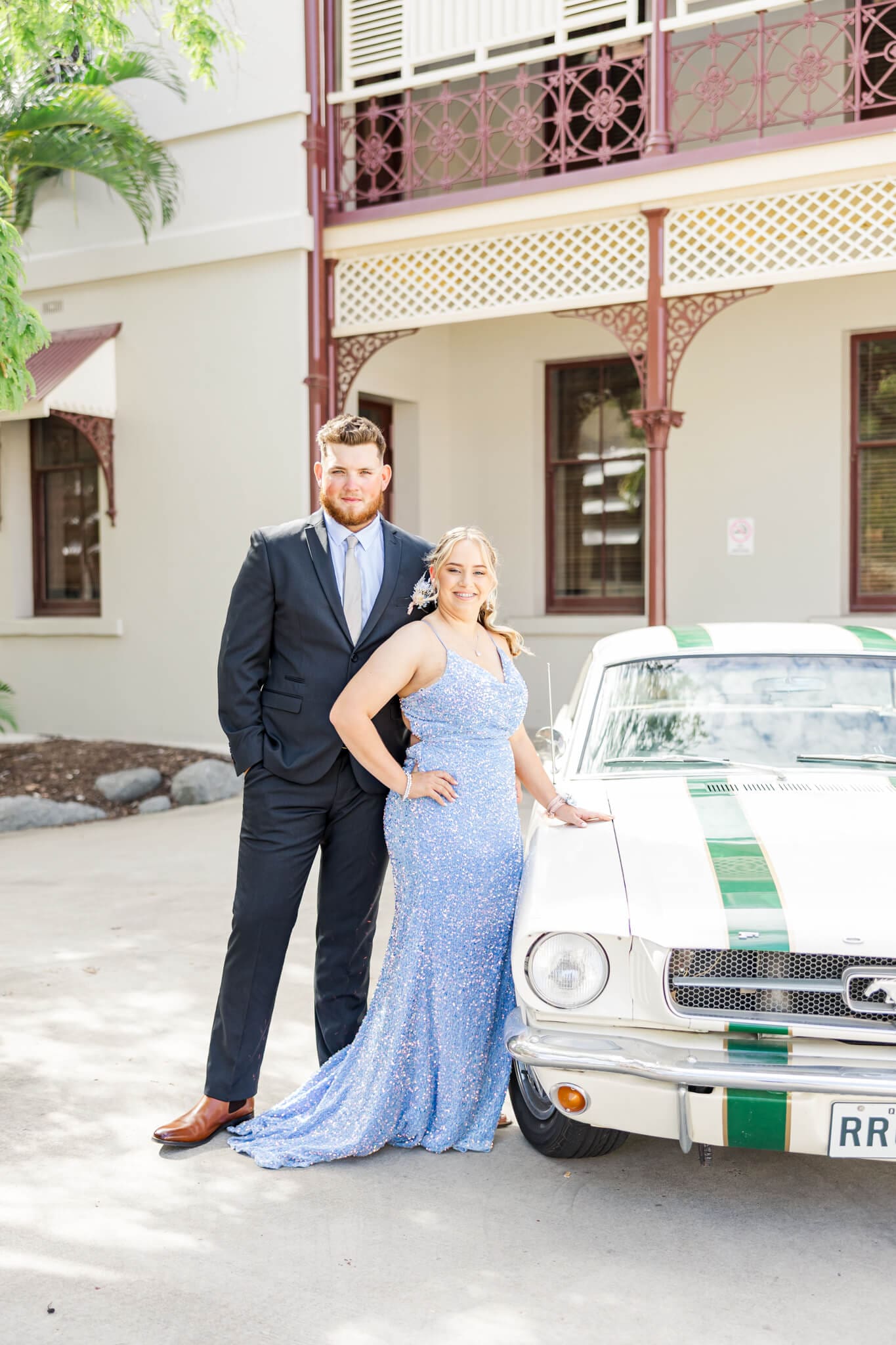 Graduation photo of couple standing near cream vintage car during their formal session. Rockhampton, Queensland.