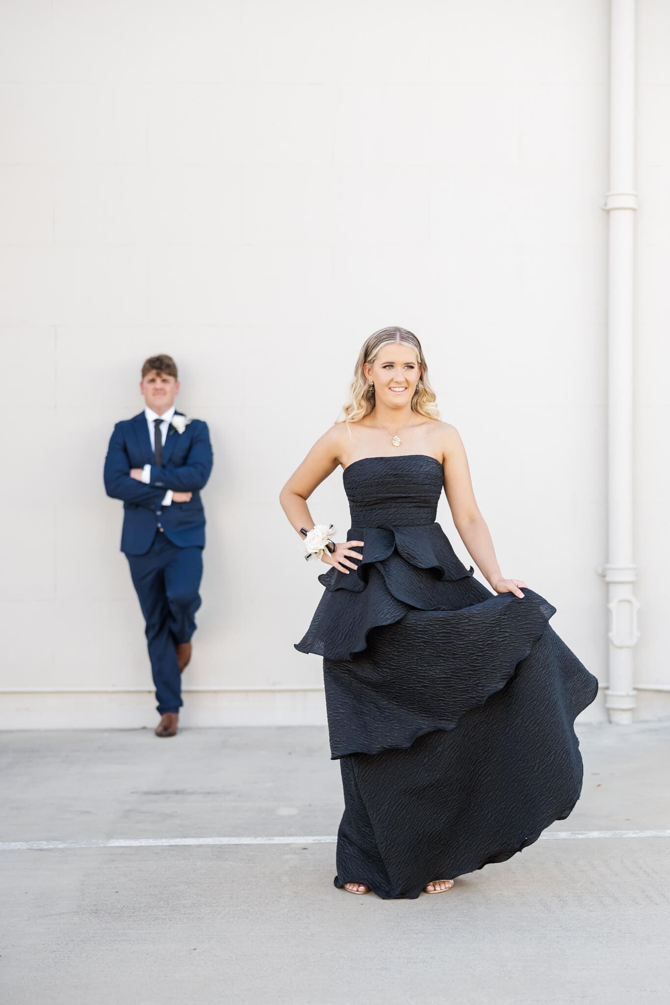 High school graduates posing against a cream wall for their formal session. Captured by Julie-Anne Photography.