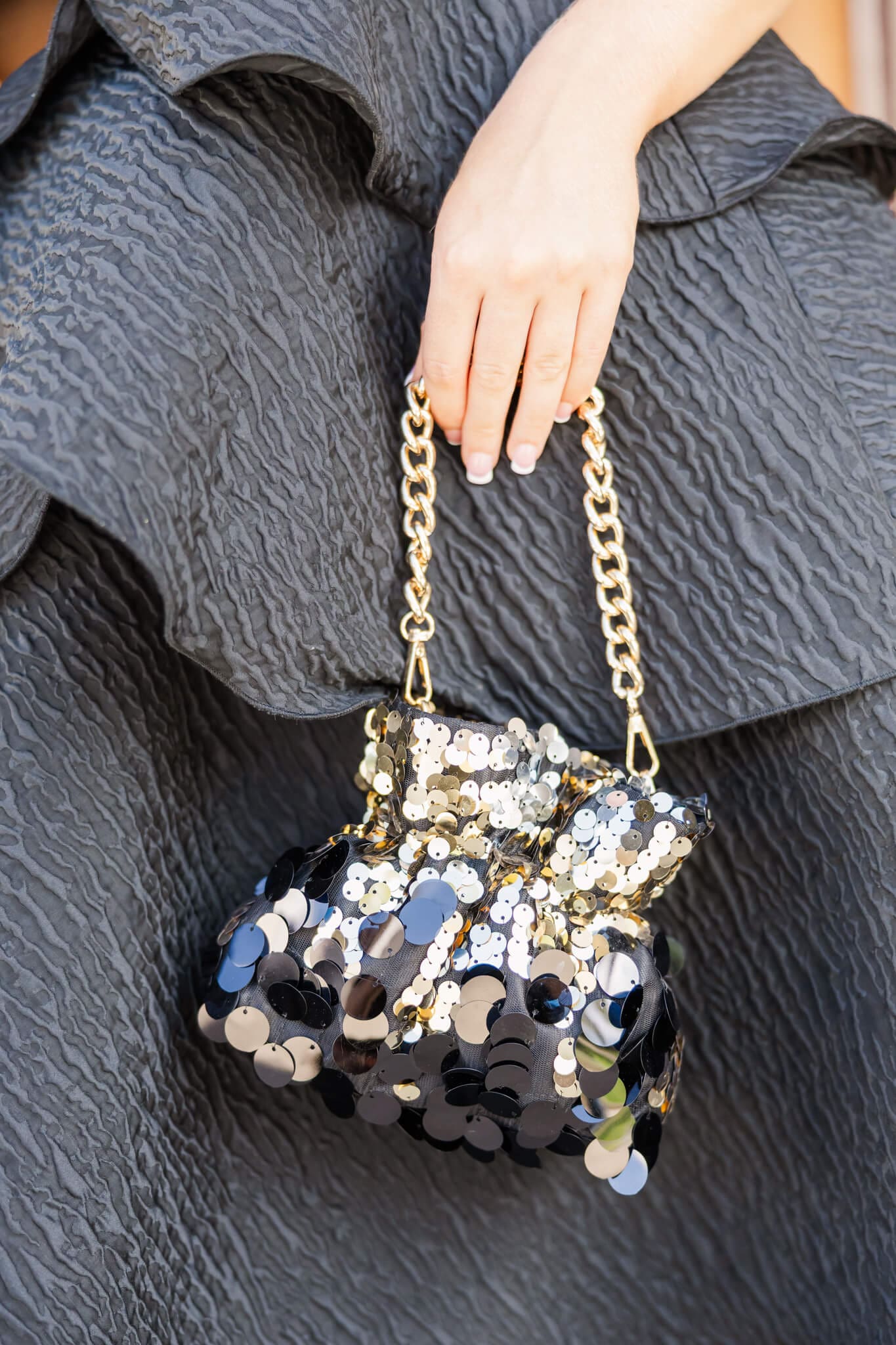 Detailed shot of a black and gold puffer handbag.