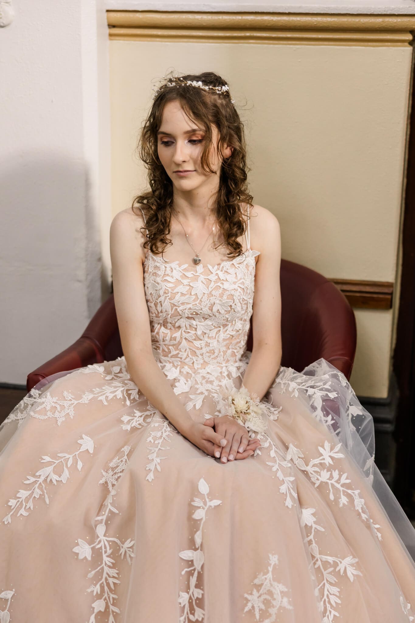 Girl posing for her formal, seated and dressed in a formal dress from Gossip Gowns. Photographed by Julie-Anne Photography.