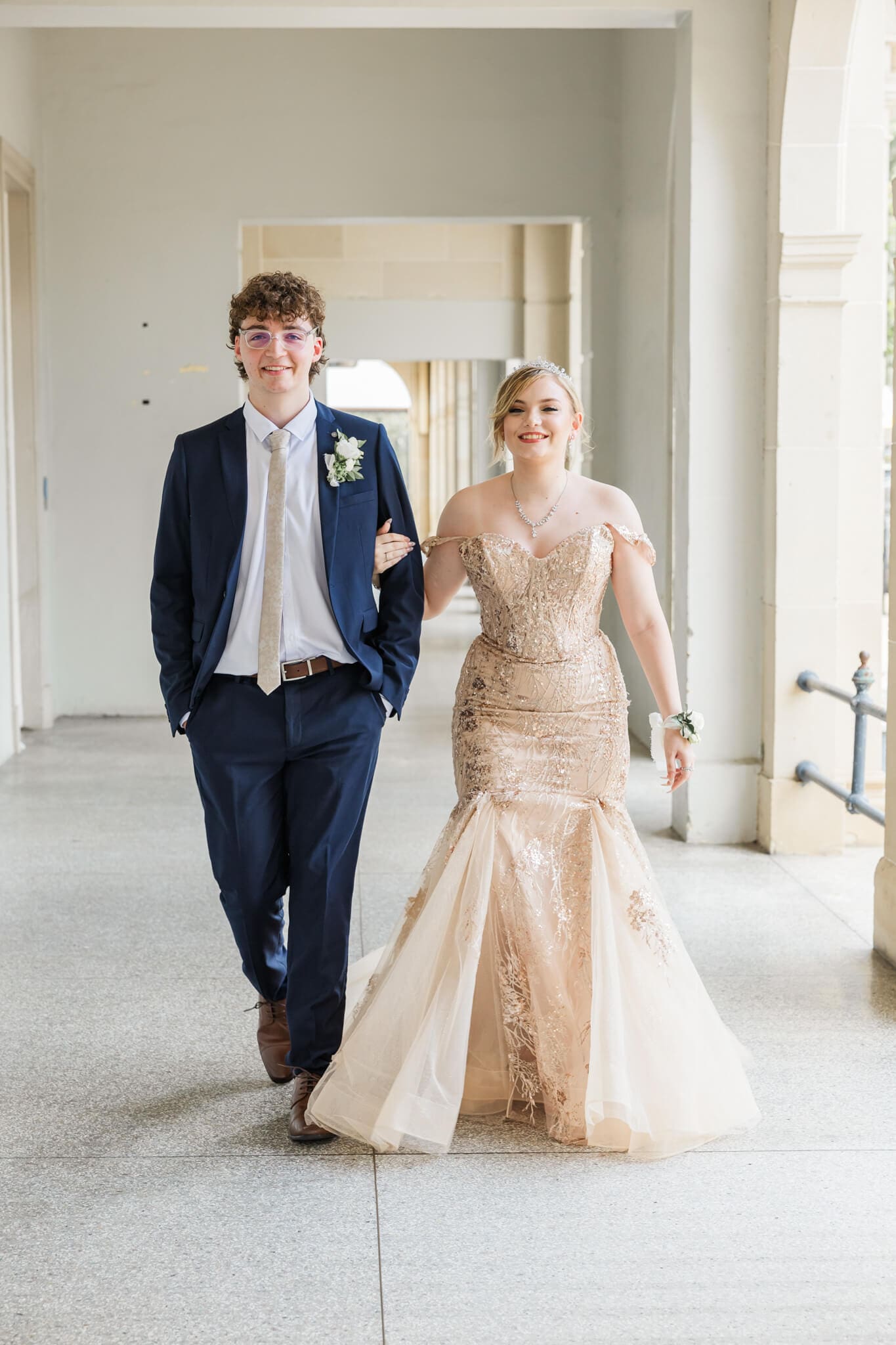 Charming image of a formal couple walking arm in arm at the Old Post Office, Rockhampton, Queensland.