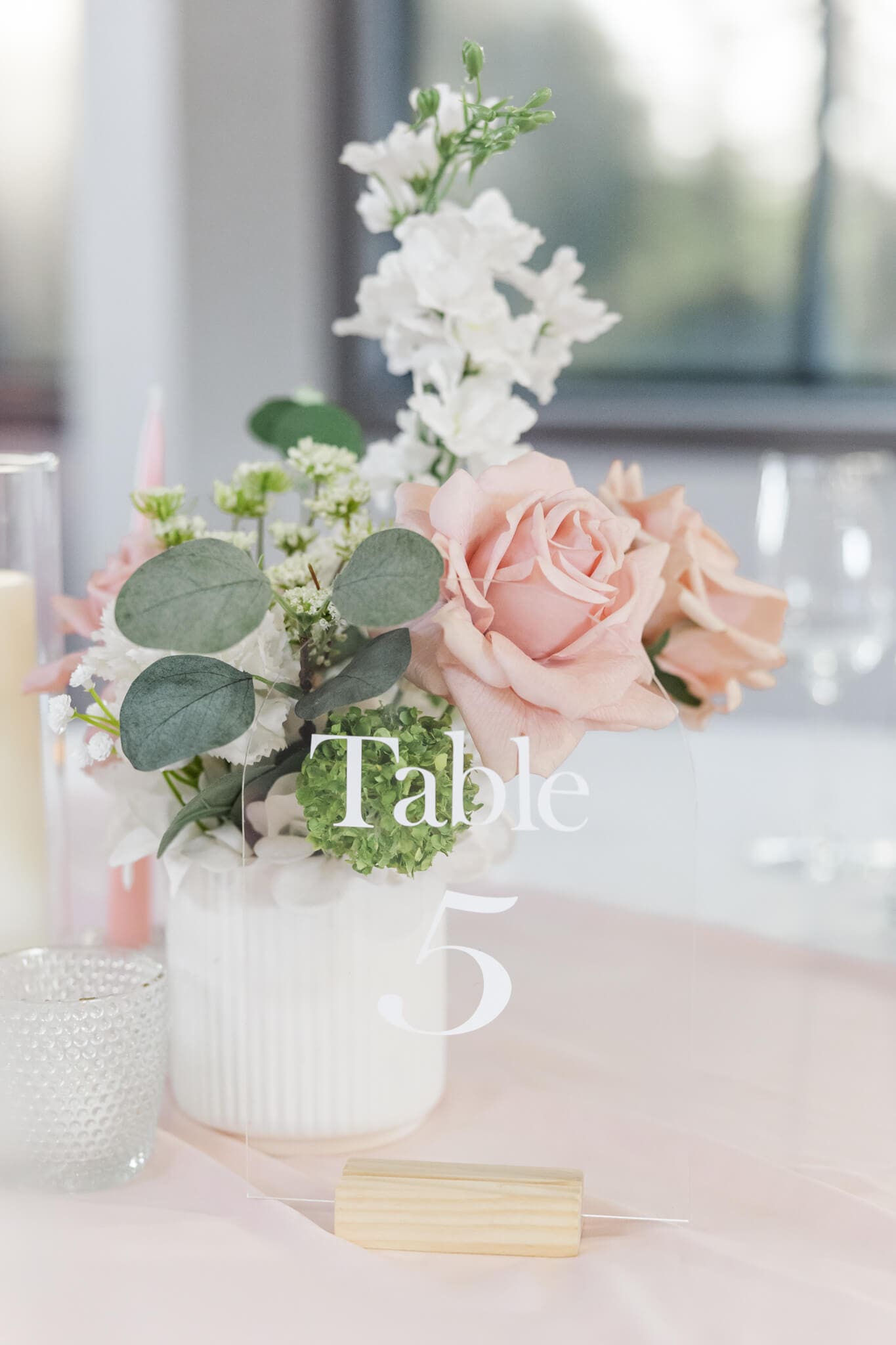 Stunning detail image of floral arrangements in a white vase with a table number next to it at a wedding reception in Rockhampton, Queensland. Captured by Julie-Anne Photography.