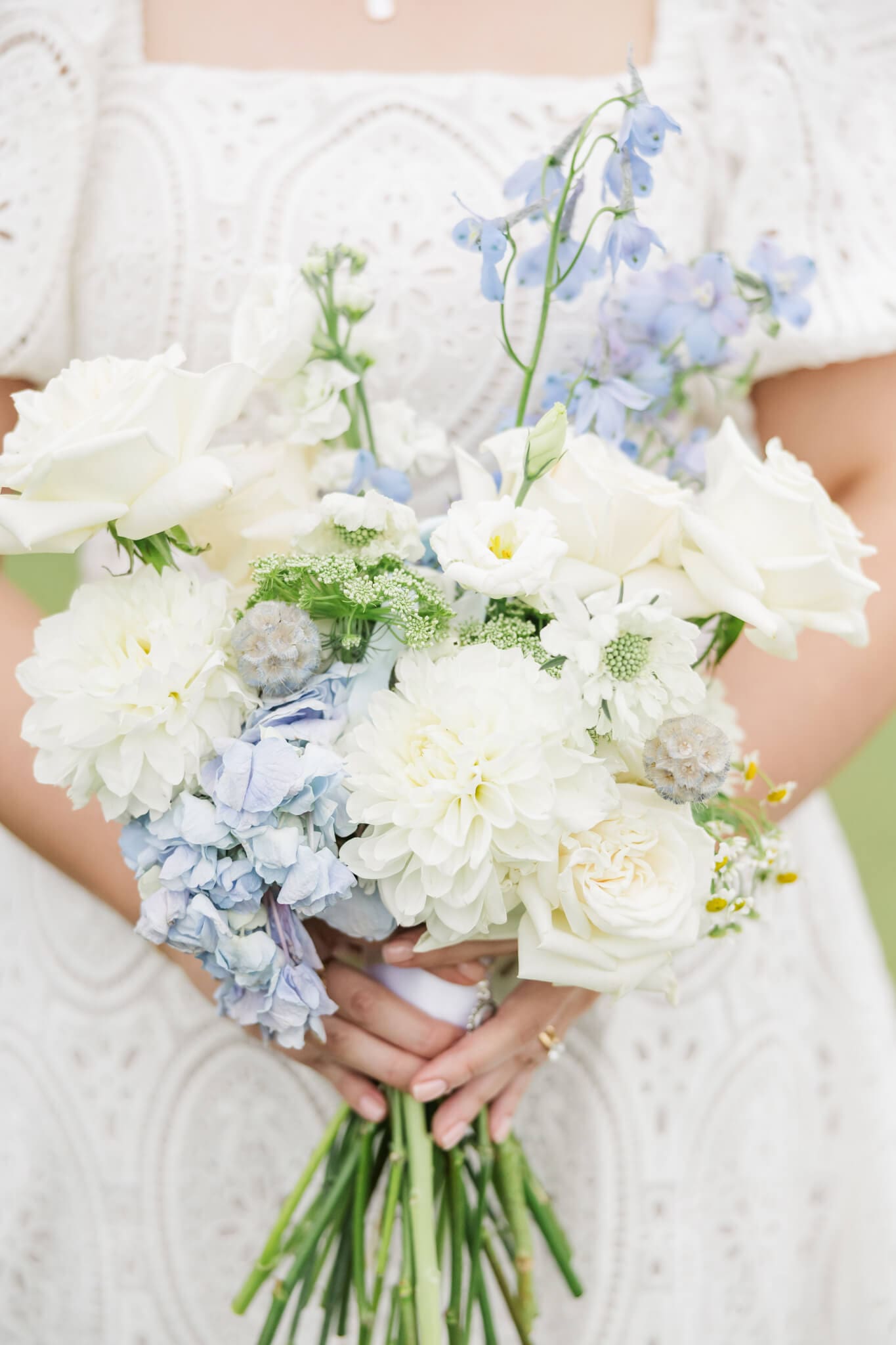 Detail Shot of a brides bouquet consisting of blue, cream and white florals.