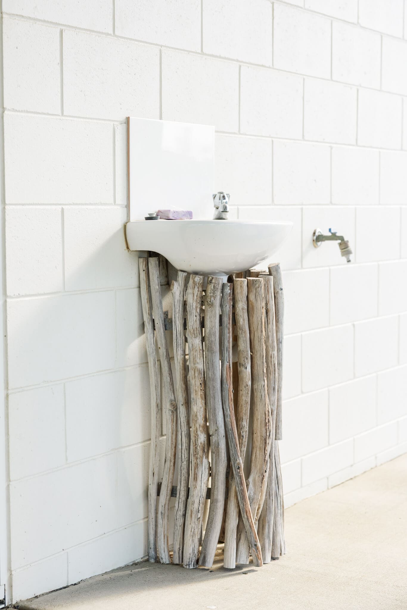 Creative wooden decor at the Salty Lime Co under a basin to give it a rustic yet luxury look.