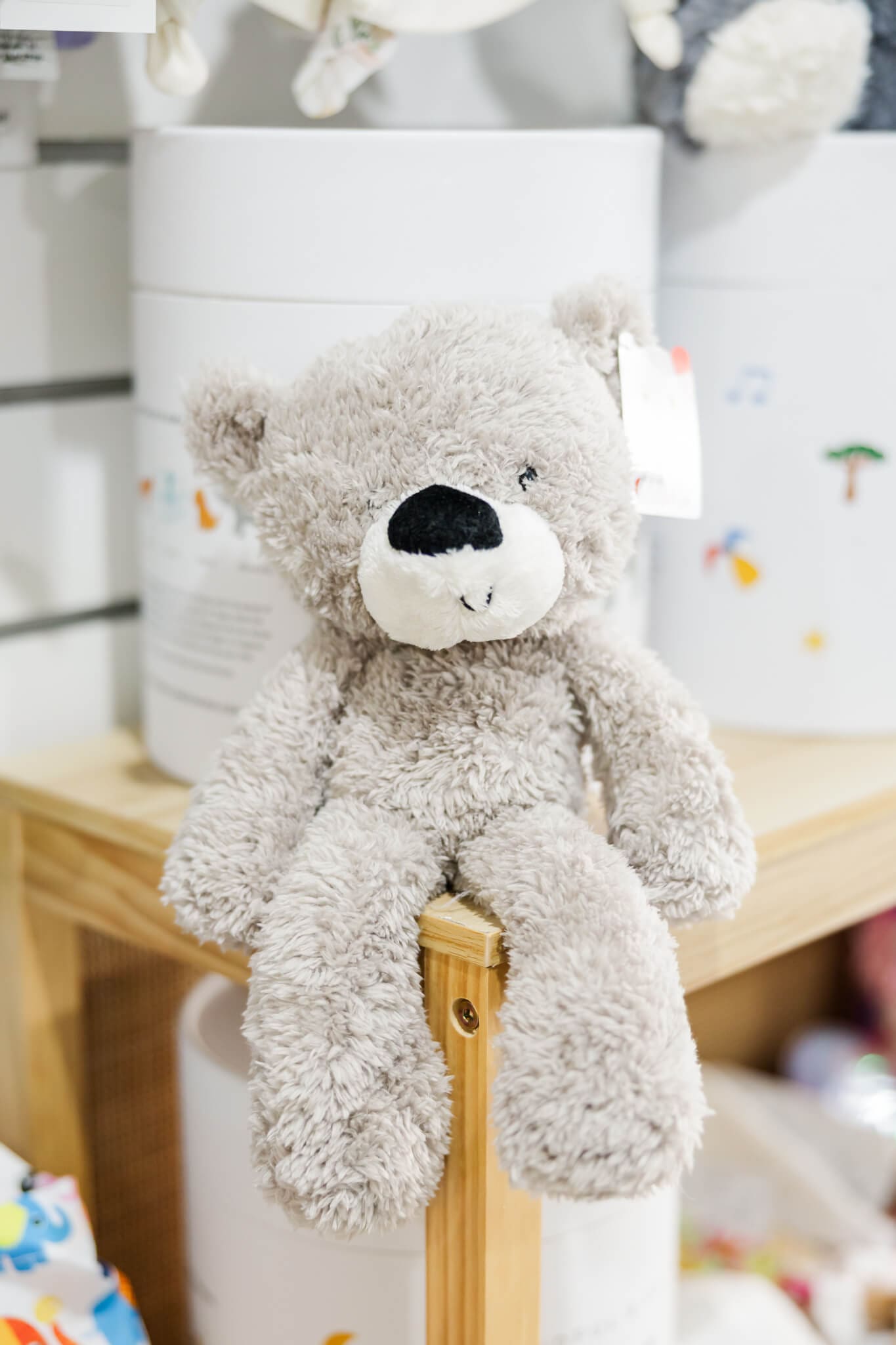 Cute grey teddy sitting on a shelf in Two Little Friends baby shop, Rockhampton.