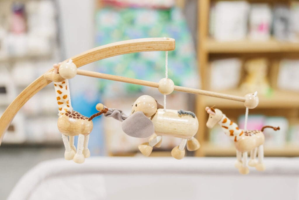 A cute little wooden mobile for a cot, on display in a baby store.