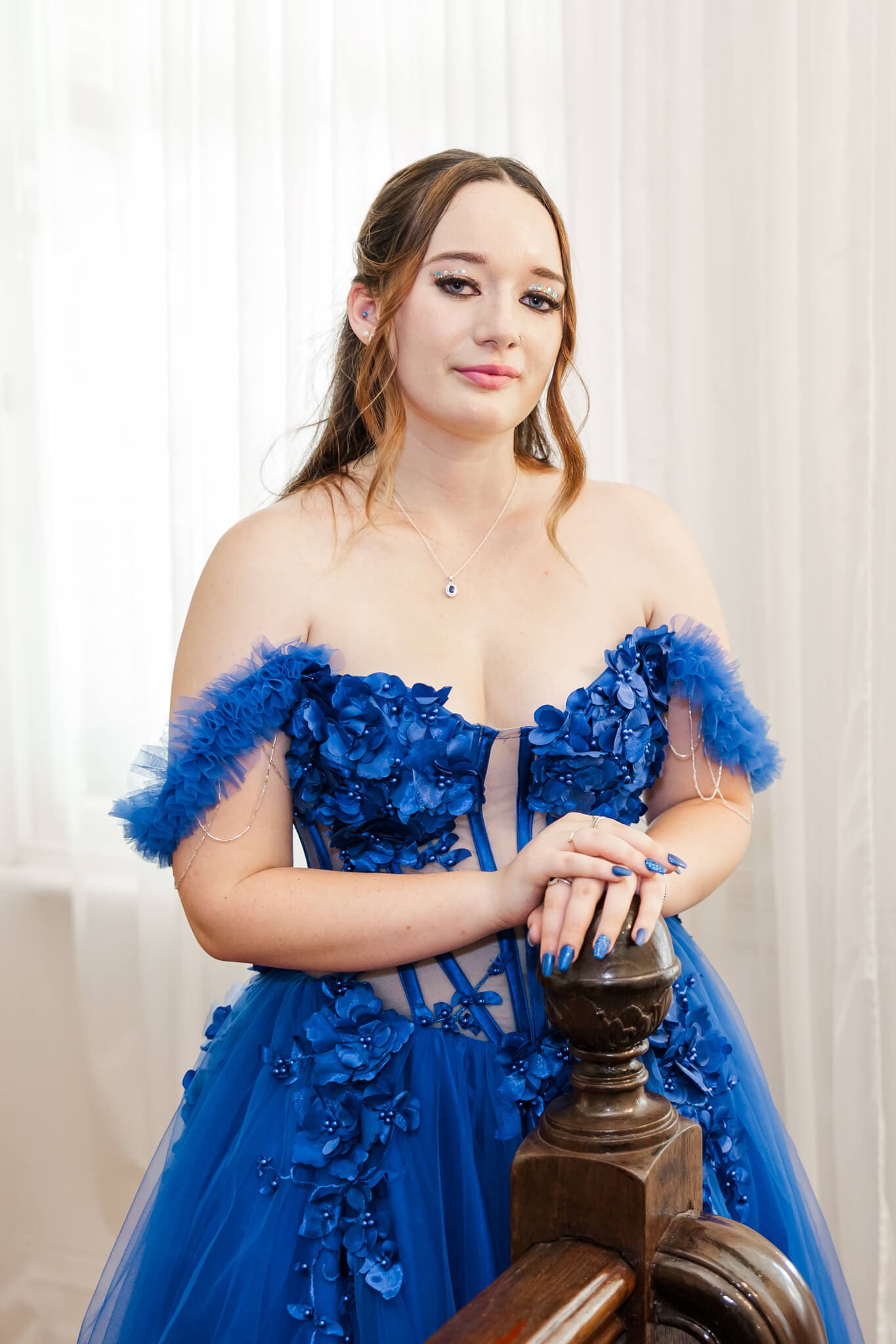 High school senior photo of a girl in a gorgeous blue dress made especially for her formal day.