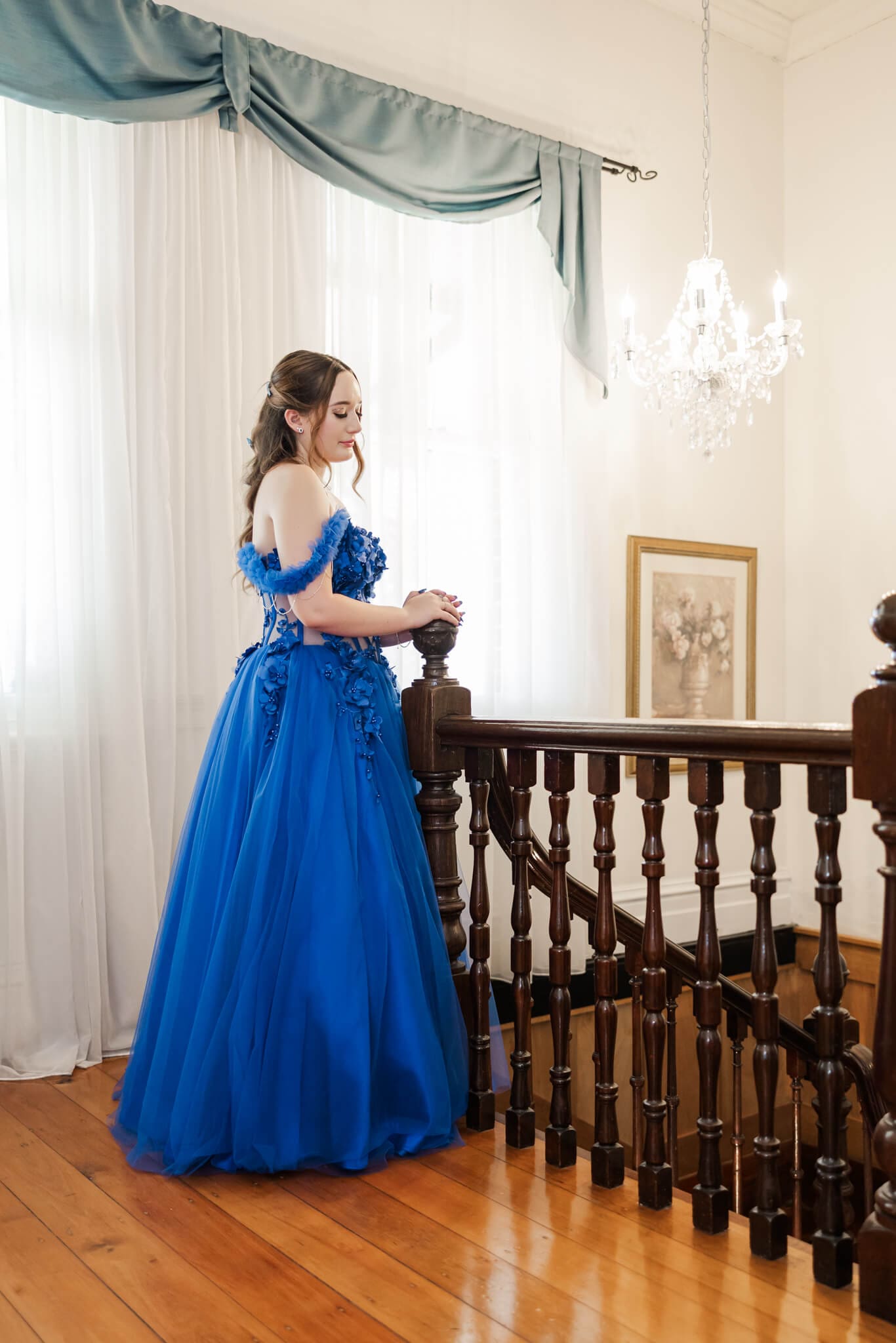 A formal picture of a graduate wearing a cinderella style gown.