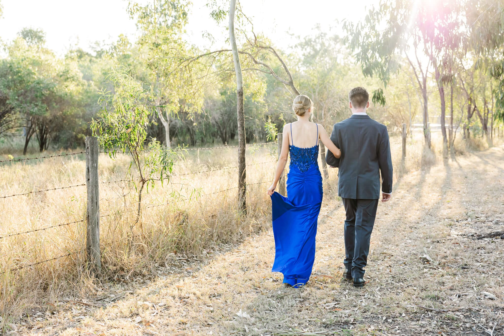 Girl in one of the many formal dresses Rockhampton, purchased from One Honey, walking next to her partner who is wearing a suit.