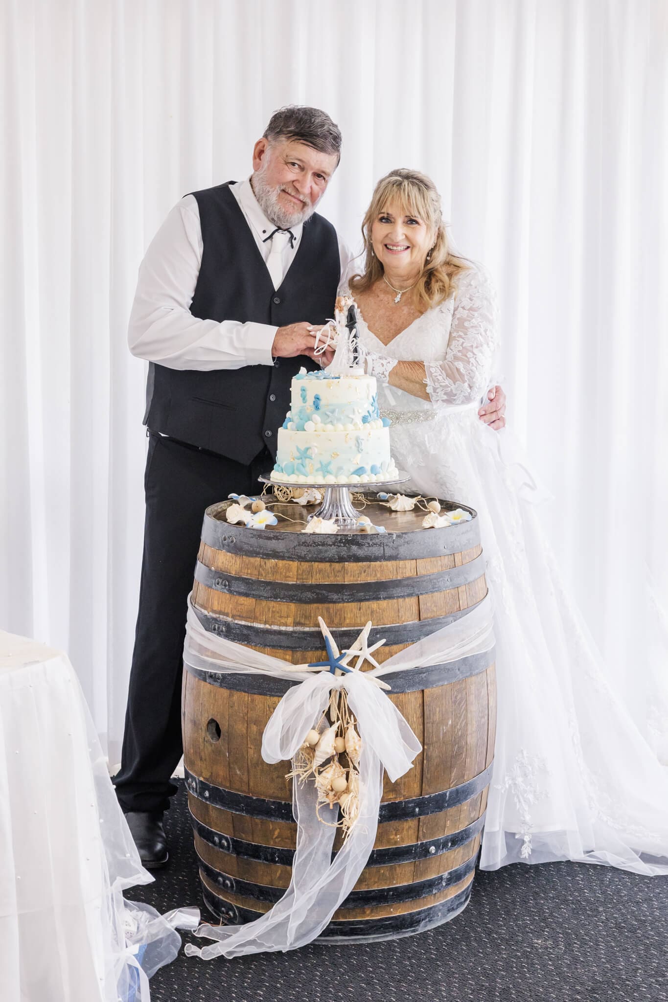 Bride and Groom cut their cake at their wedding reception. Wedding venue is Beaches Restaurant Yeppoon.
