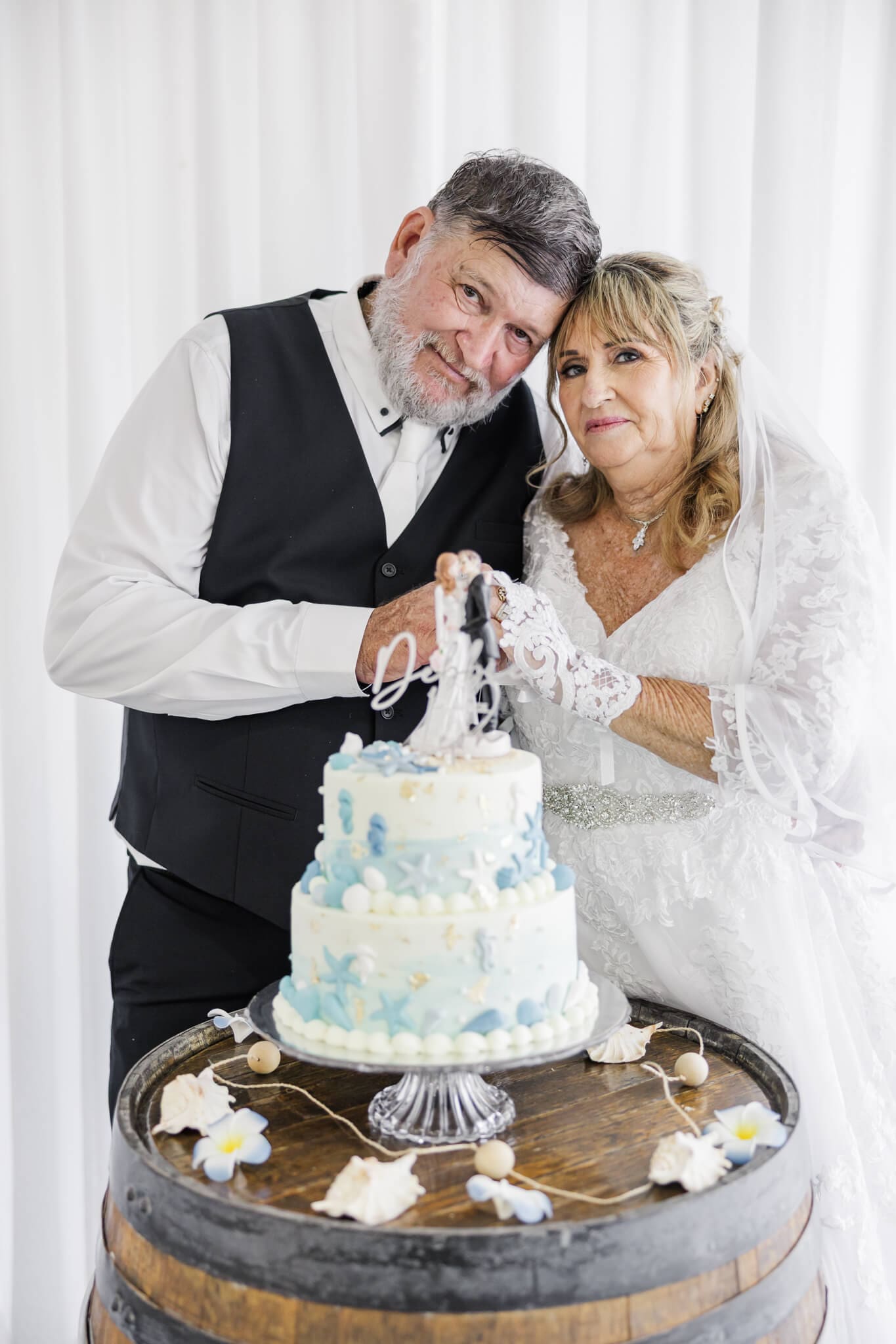 Bride and Groom cut their cake at their wedding reception. Wedding venue is Beaches Restaurant Yeppoon.