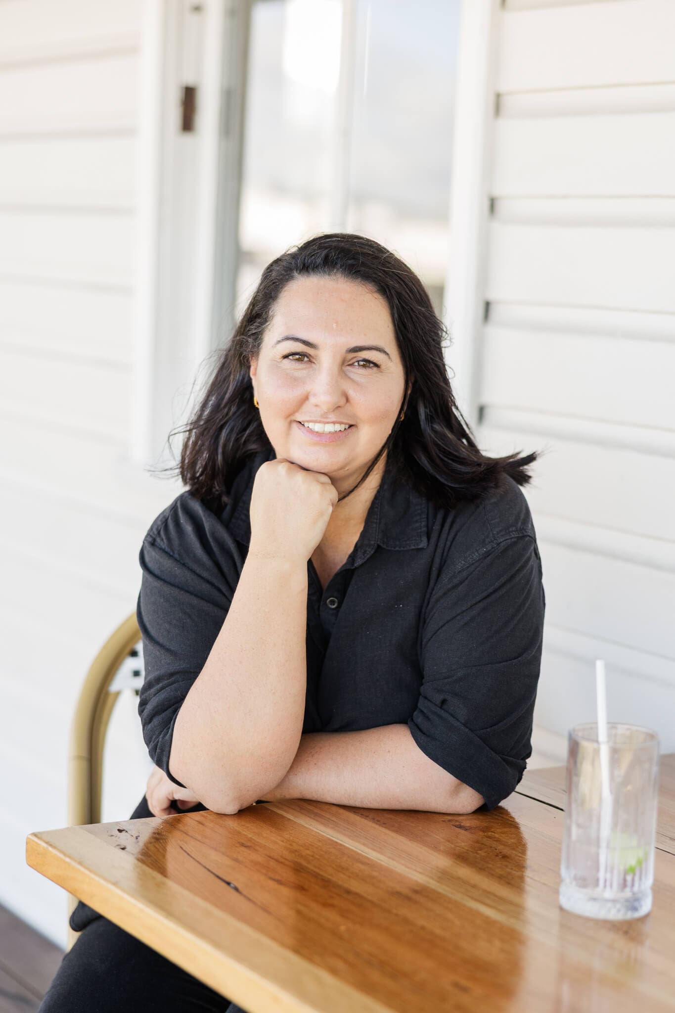 Gina from Best Day Ever Events, ready to be the ultimate wedding planner, sitting at a table, ready to chat.