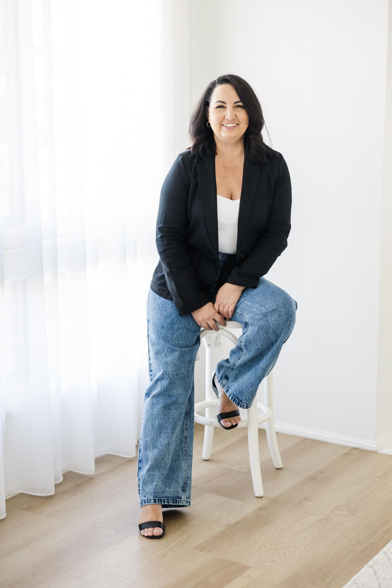 Meet Gina, a wedding planner, sitting on a stool for a brand shoot with Julie-Anne Photography