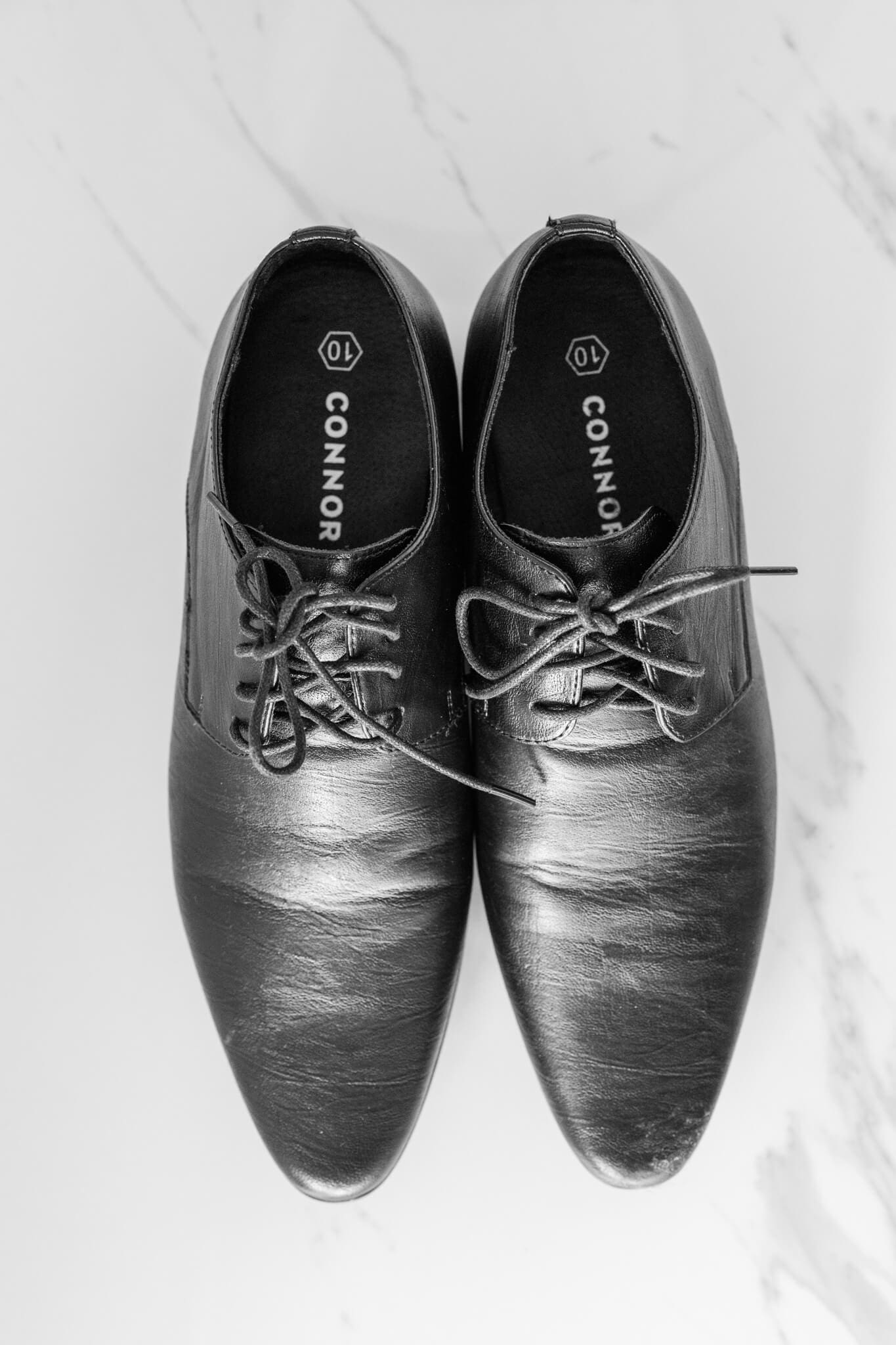 Black and white image of groom's wedding shoes. Captured by Julie-Anne Photography, Rockhampton wedding photographer.