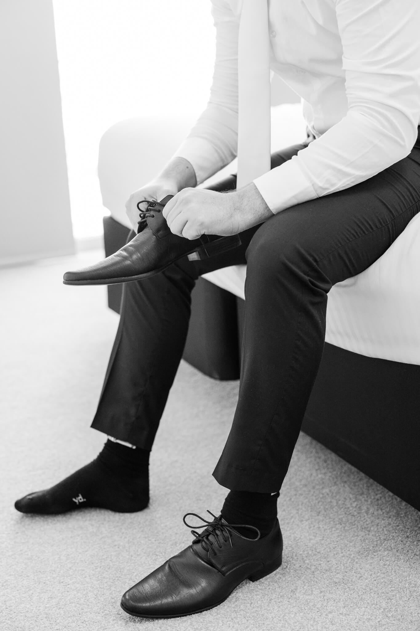 Groom putting on shoes in preparation for his wedding. Captured by Rockhampton Wedding Photographer Julie-Anne Photography