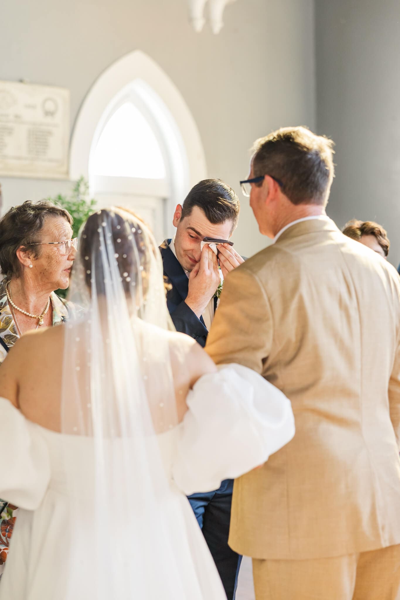 Emotional image of the groom as he greet his bride after she walks down the aise.
