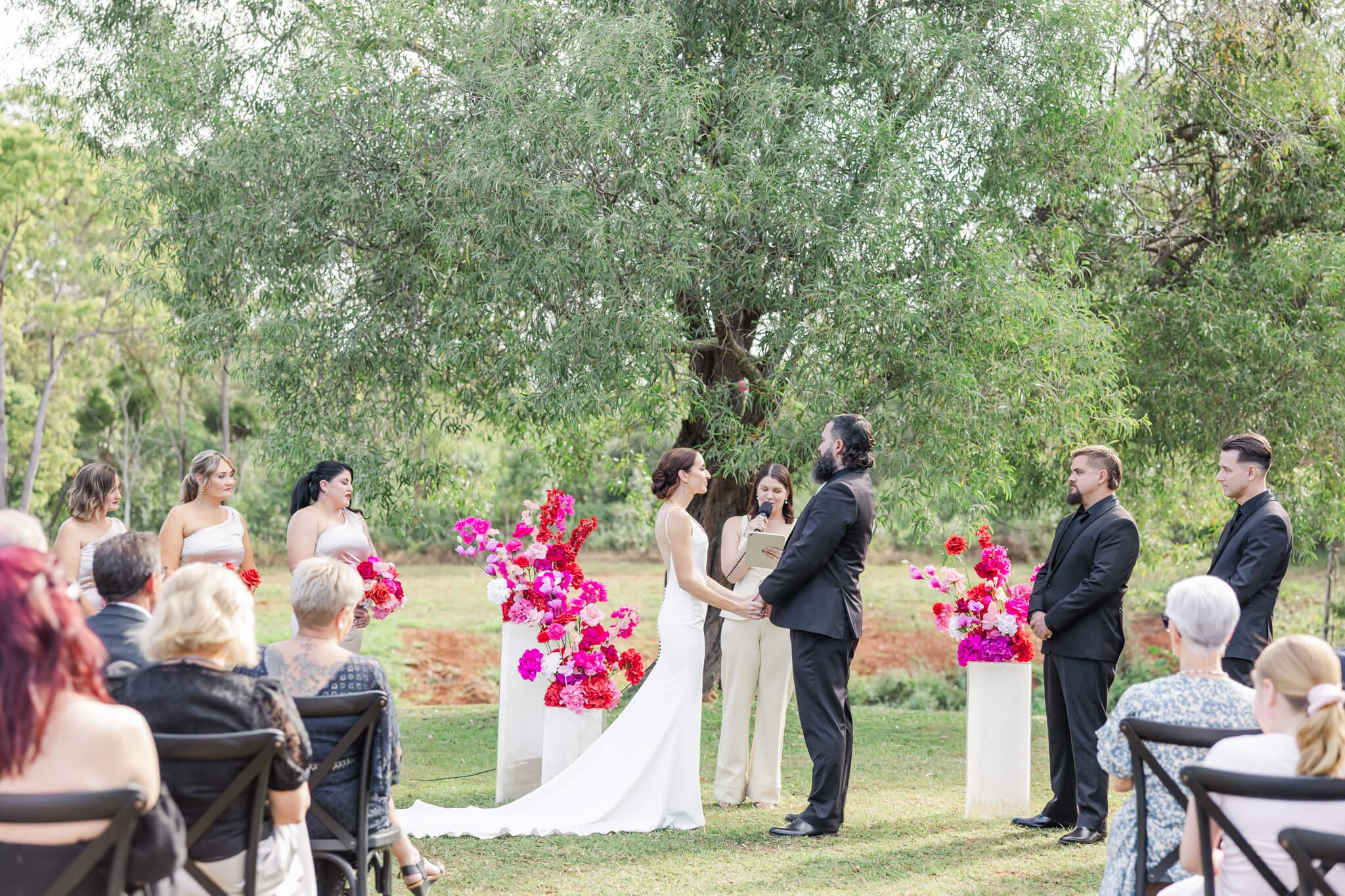 Bride and Groom exchanging vows during their wedding ceremony at The Orchard Yeppoon. Captured by Julie-Anne Photography.