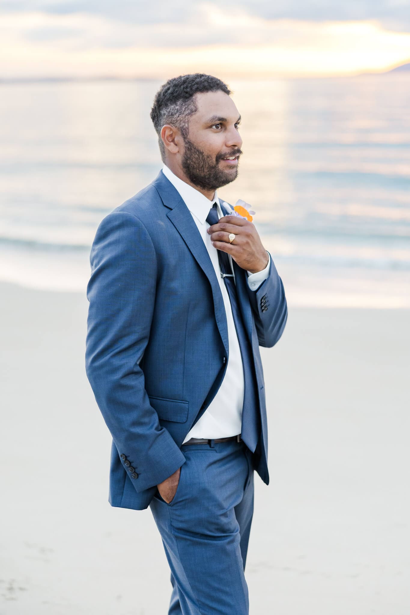 Photo of a groom on his wedding day with the sunset in the background.