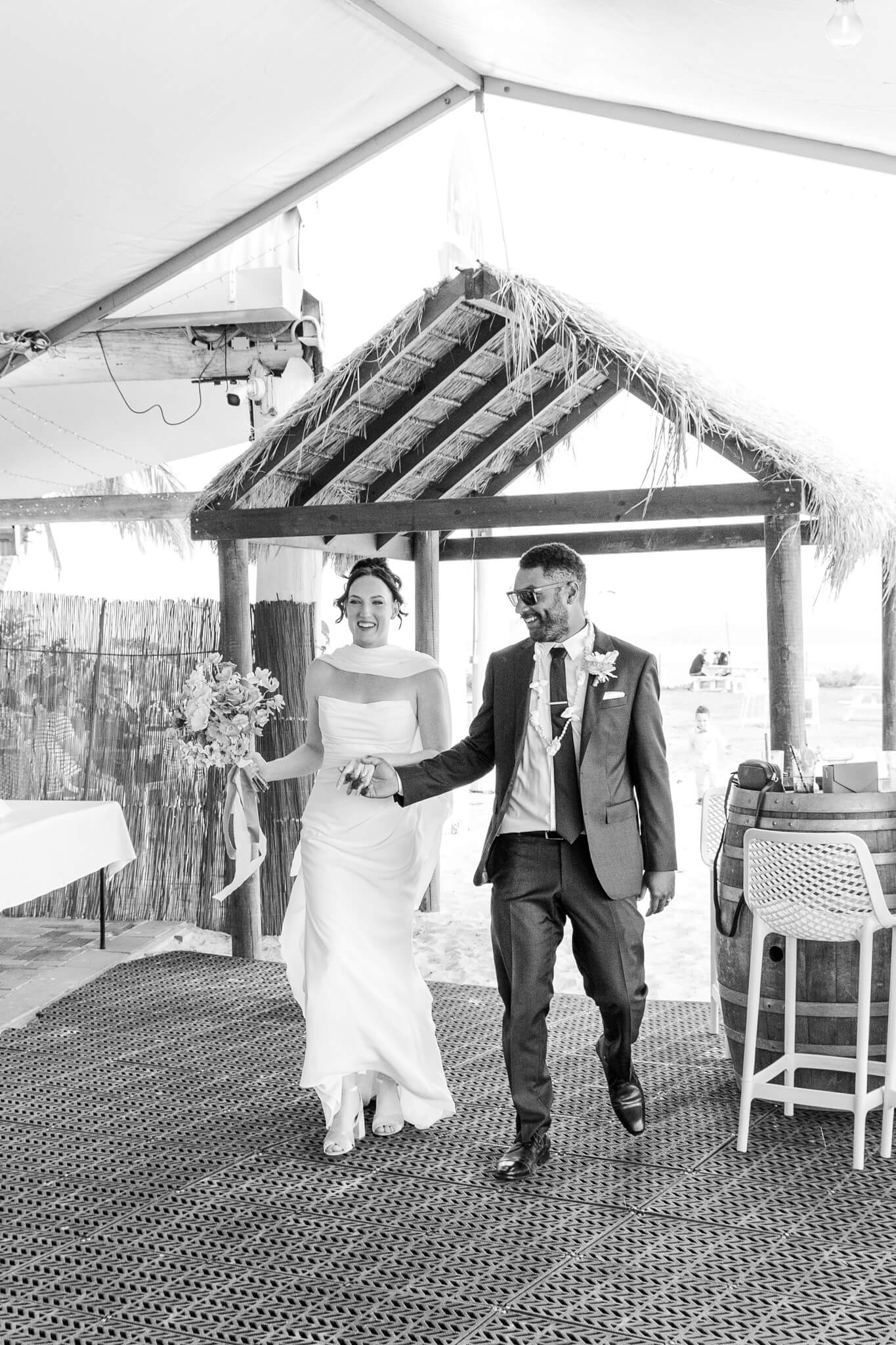 Black and White portrait of bride and groom making an entrance to their reception.