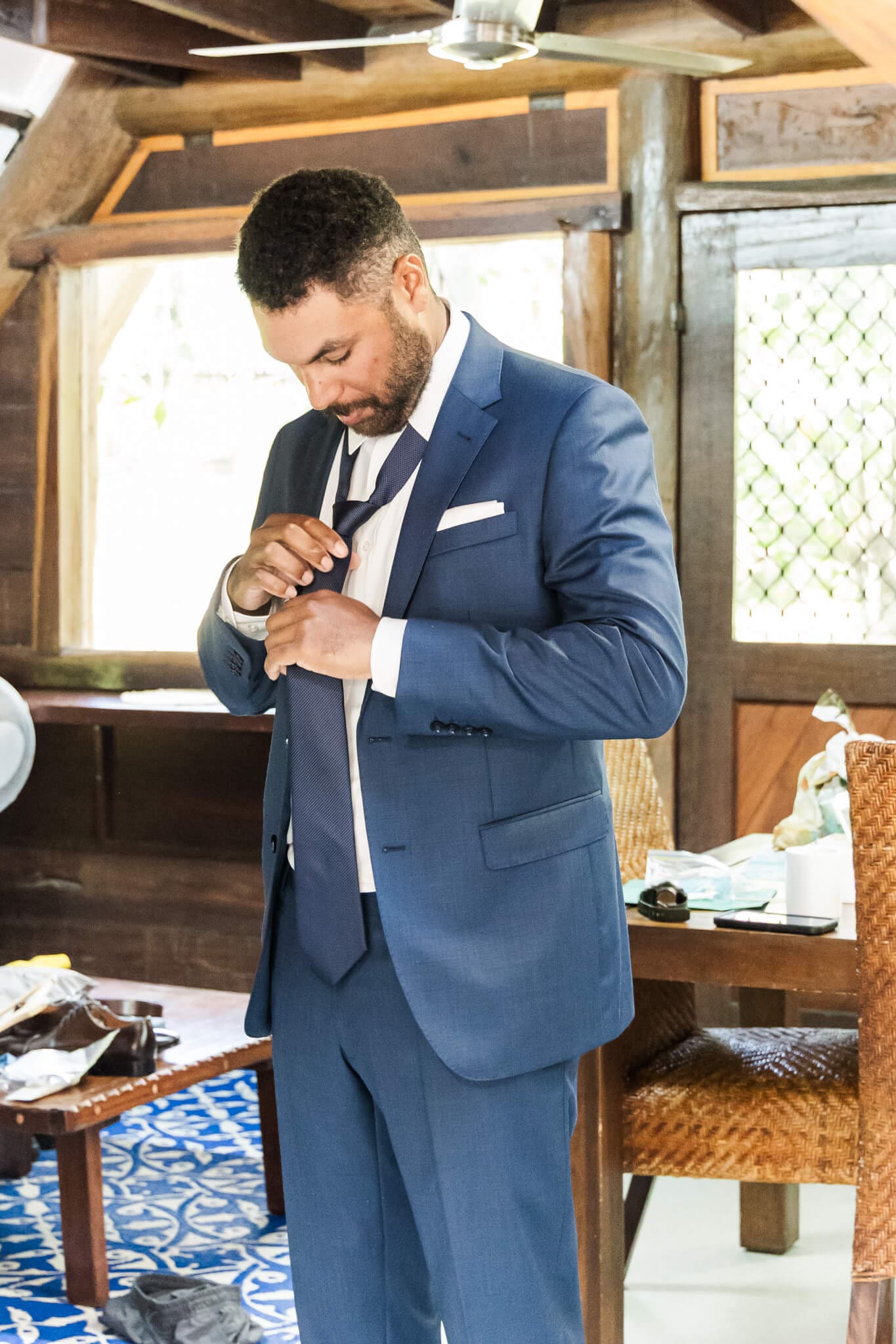Groom prepares for his wedding, putting his tie on.
Location is Great Keppel Island Hideaway.