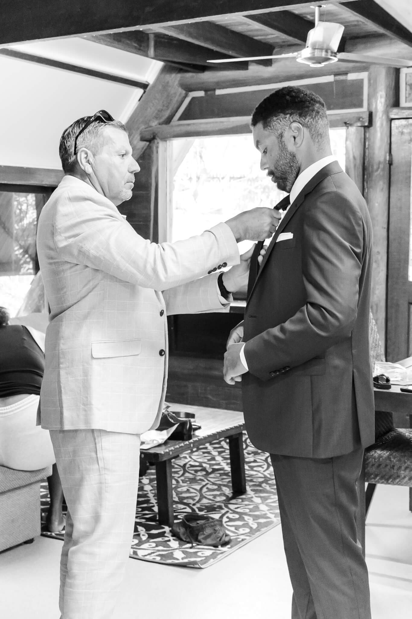 Groom prepares for his wedding, his dad assists with putting his tie on.
Location is Great Keppel Island Hideaway.
