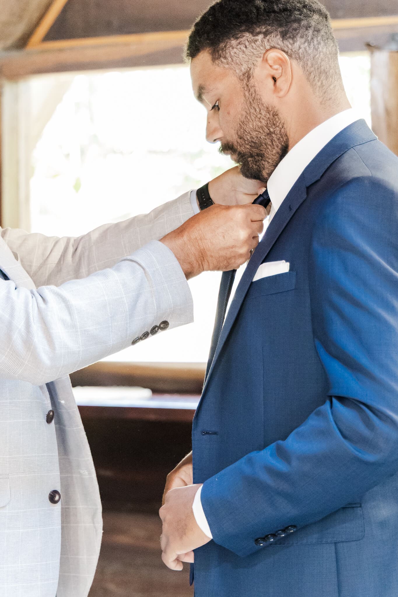 Groom prepares for his wedding, his dad assists with putting his tie on.
Location is Great Keppel Island Hideaway.