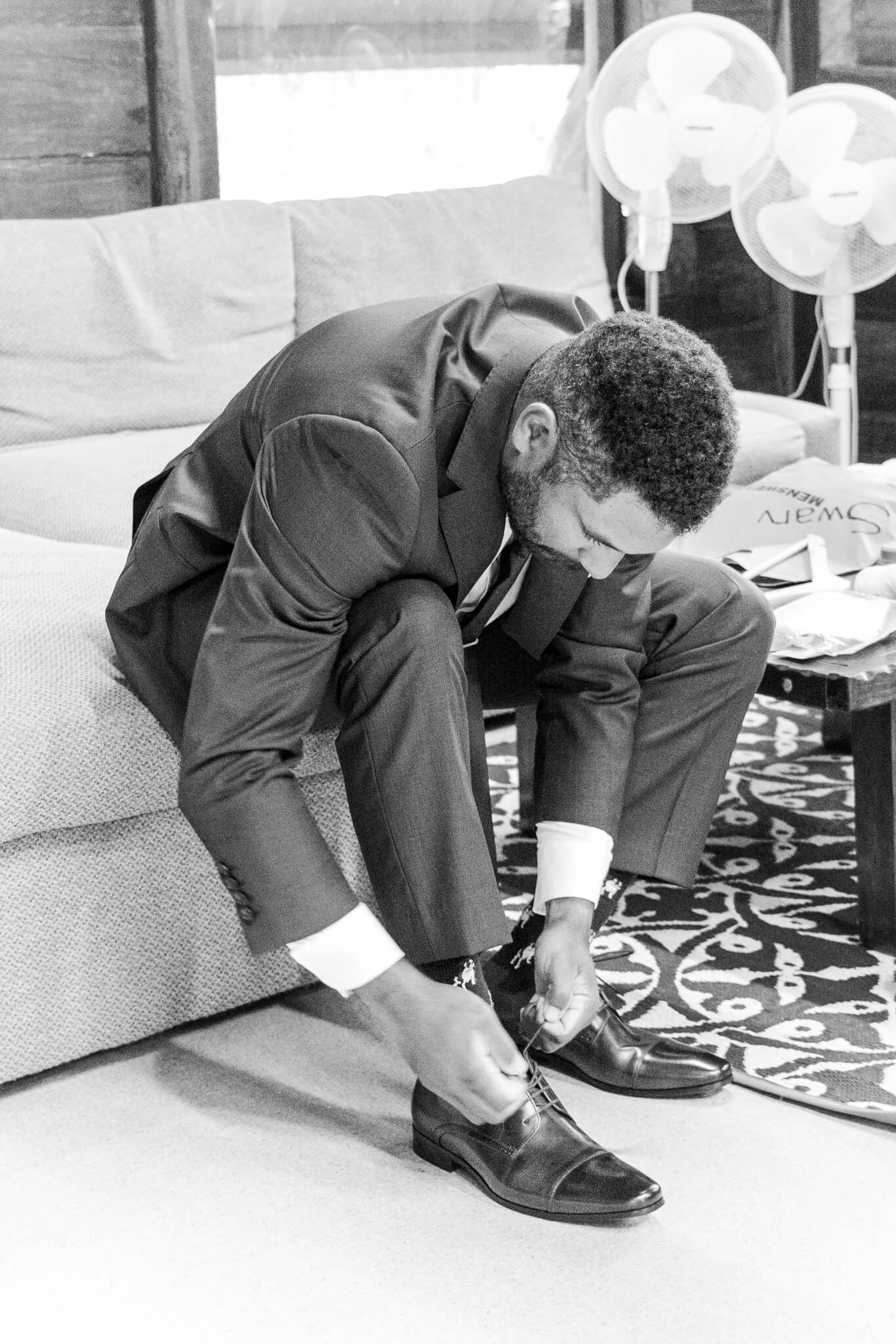 Groom prepares for his wedding, putting his shoes on.
Location is Great Keppel Island Hideaway.