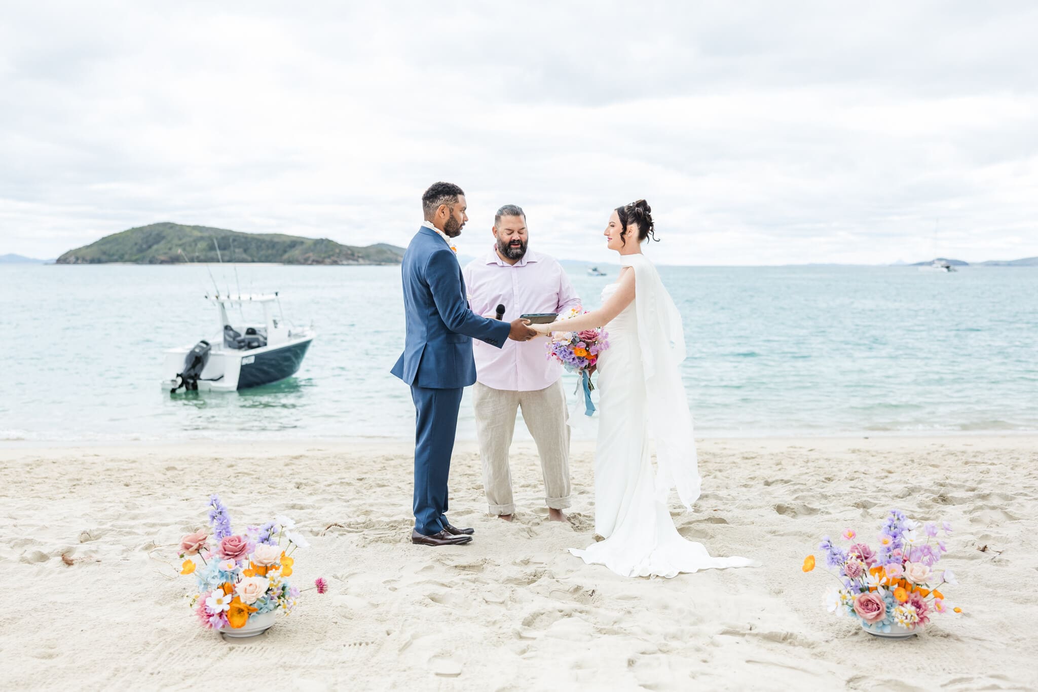 Wedding ceremony at the Great Keppel Island Hideaway, with the bride and Groom exchanging vows in front of a beautiful blue ocean. Captured by Julie-Anne Photography.