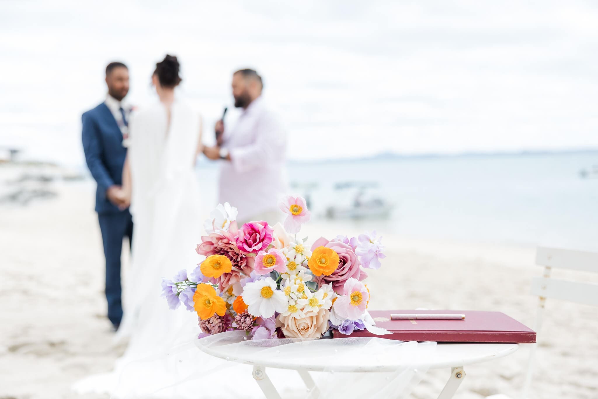 Wedding ceremony at the Great Keppel Island Hideaway, with the bride and Groom exchanging vows in front of a beautiful blue ocean. Captured by Julie-Anne Photography.