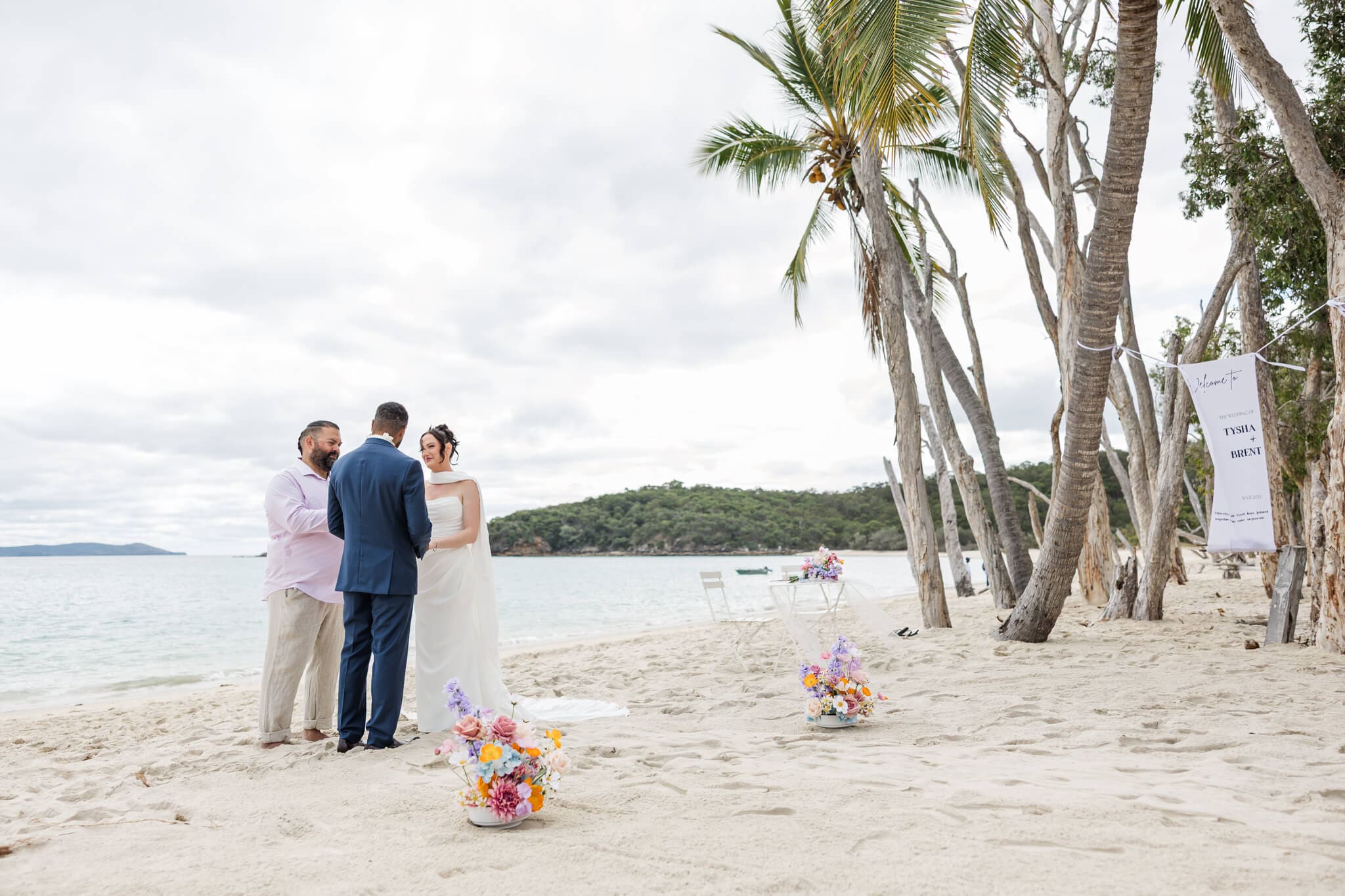 Wedding ceremony at the Great Keppel Island Hideaway, with the bride and groom exchanging vows in front of a beautiful blue ocean. Captured by Julie-Anne Photography.