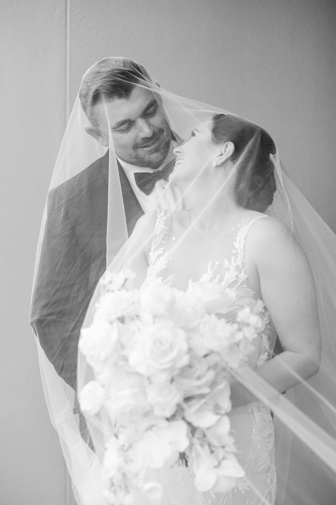 Bride and groom share a moment under the veil. Located at Headricks Lane, Rockhampton wedding venue.