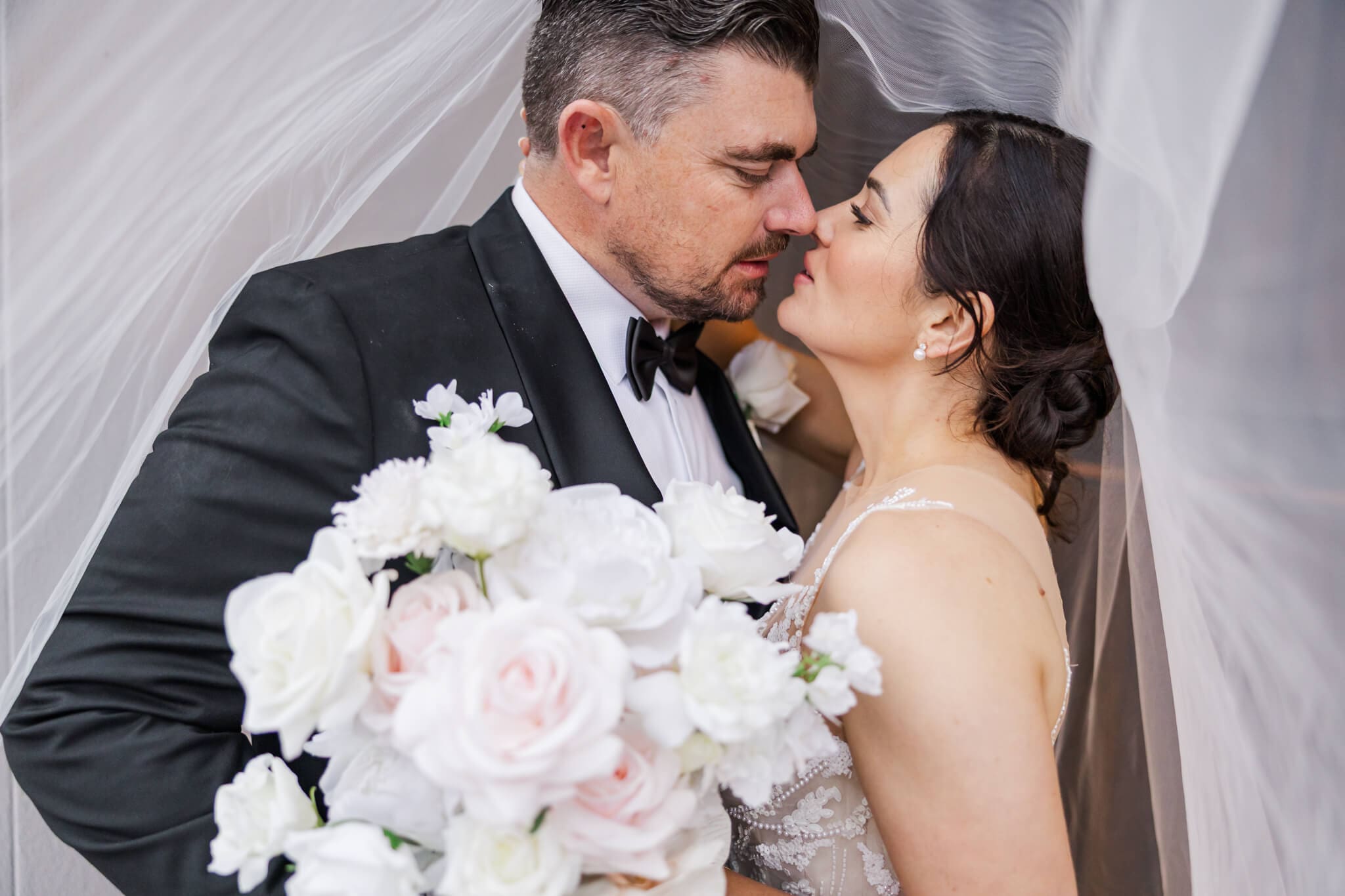 Bride and groom share a moment under the veil. Located at Headricks Lane, Rockhampton wedding venue.