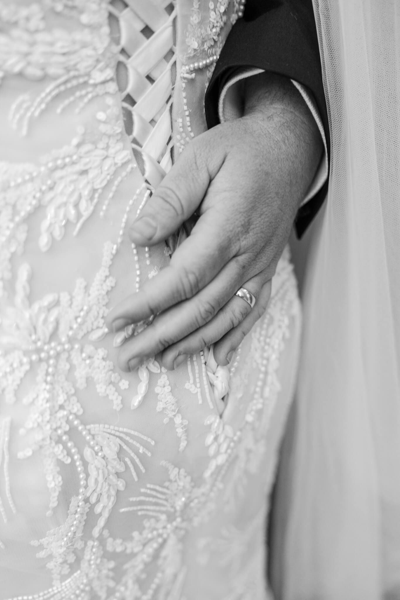 Detail shot of grooms hand on brides waist, with wedding ring on his finger. Rockhampton Wedding photographer Julie-Anne Photography