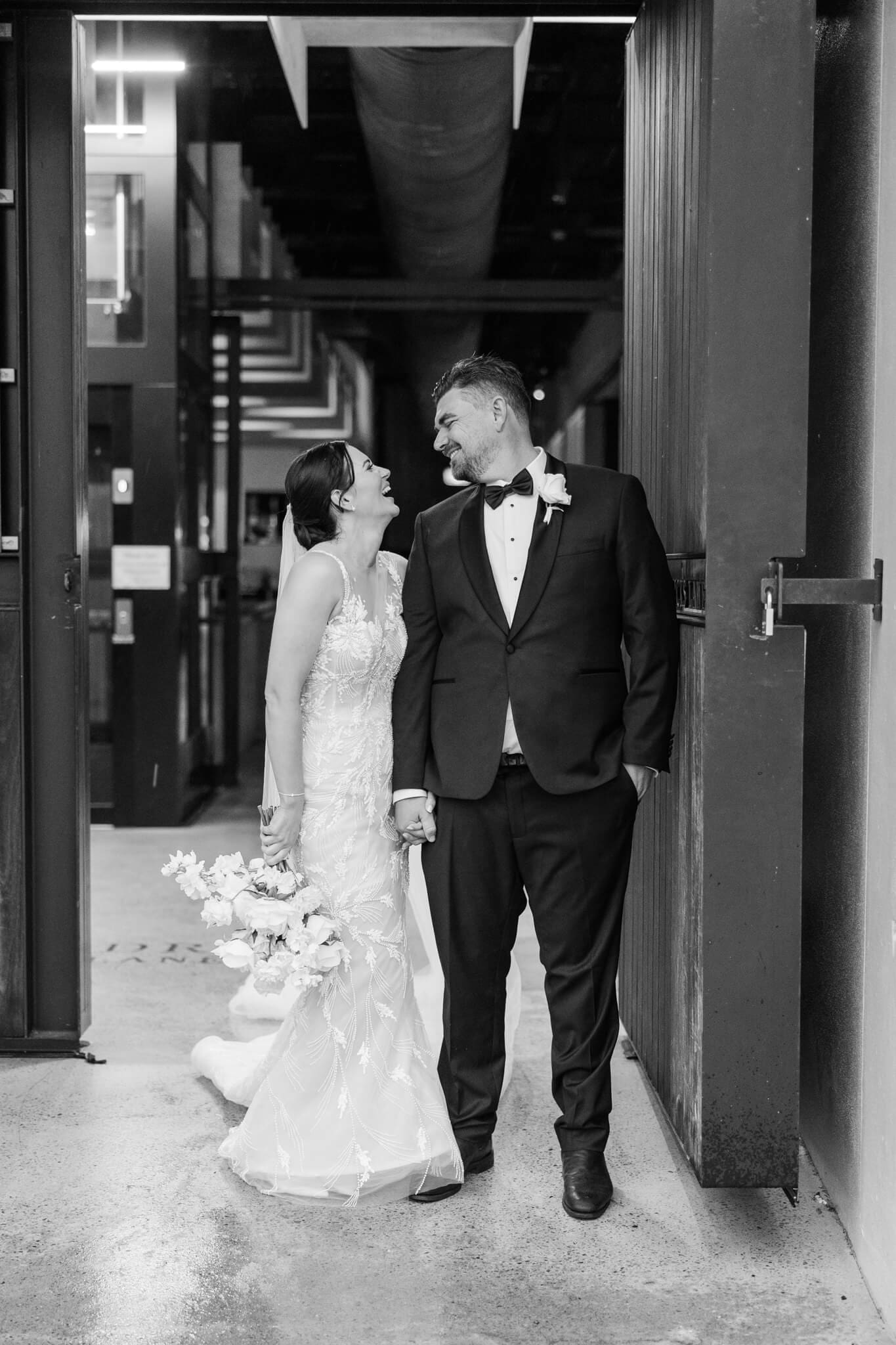 Bride and groom looking affectionately at each other at their wedding venue entrance, Headricks Lane.