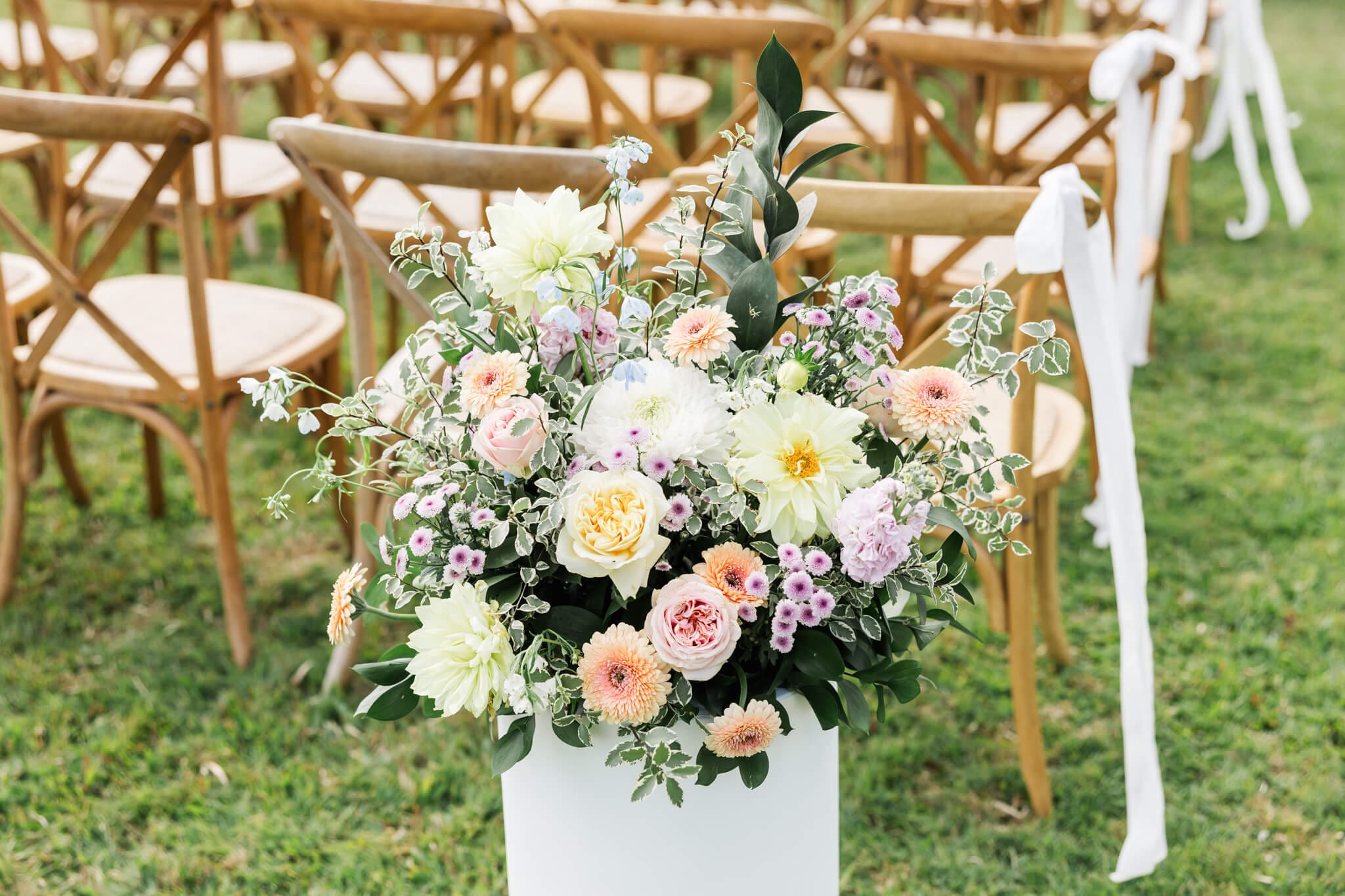 Floral set up at a wedding venue near Yeppoon. Beautiful cream, white, apricot and pink florals in a white plinth.