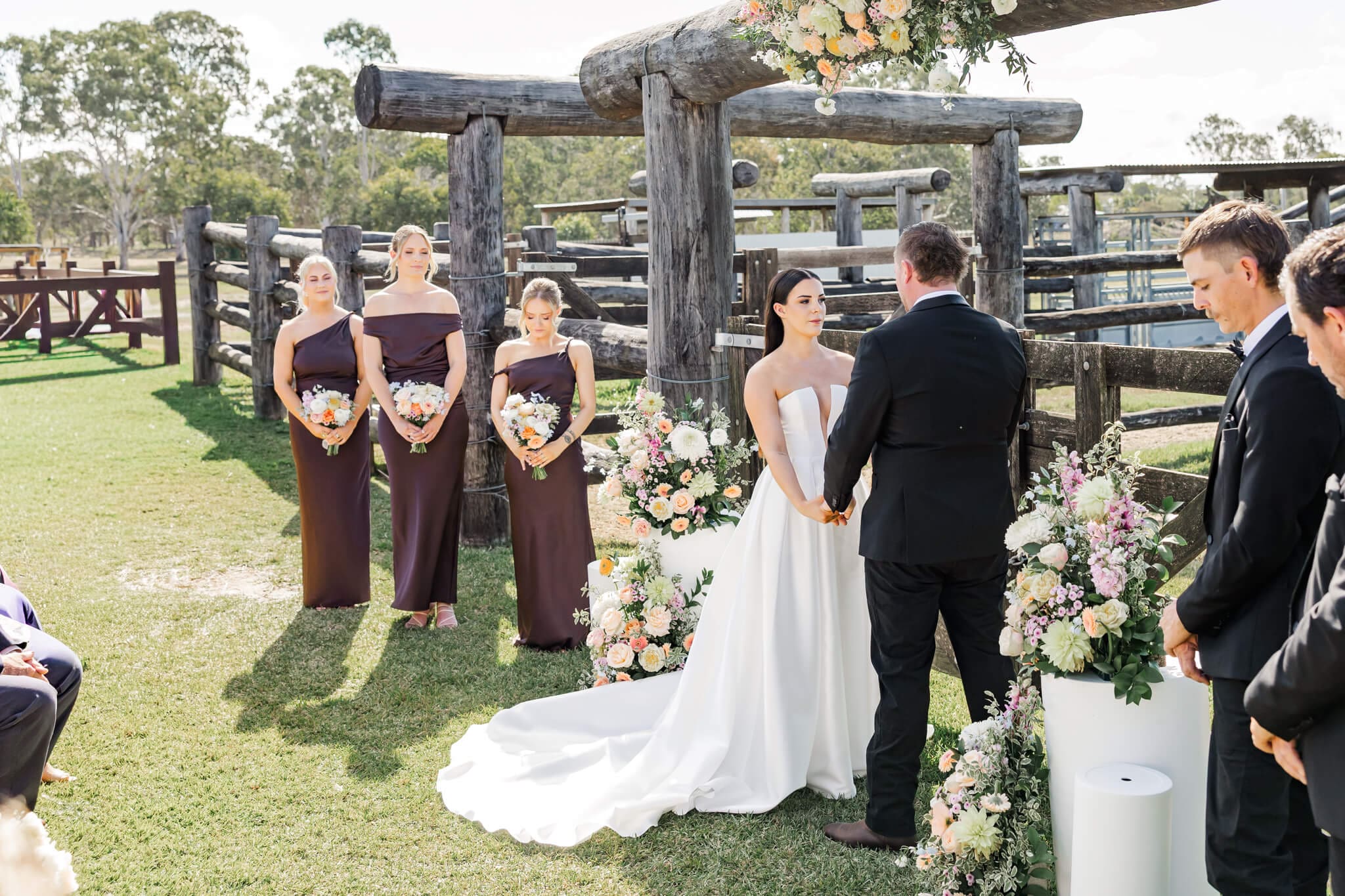 Wedding ceremony at the Yeppoon Wedding venue near the set of yards area. Stunning florals surround the bride and groom.