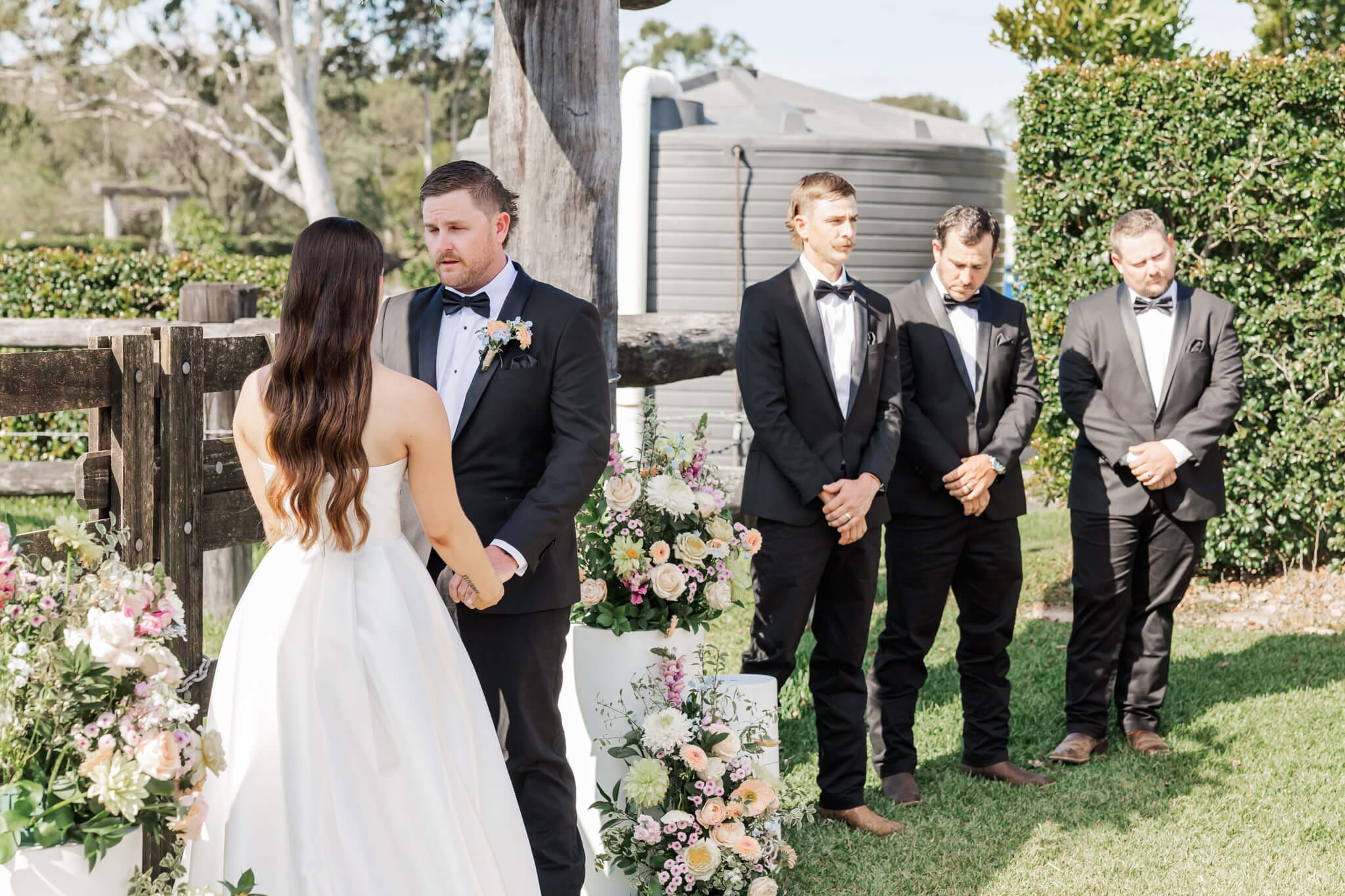 Wedding ceremony at the Paddock Yeppoon near the yard area. Stunning florals surround the bride and groom.