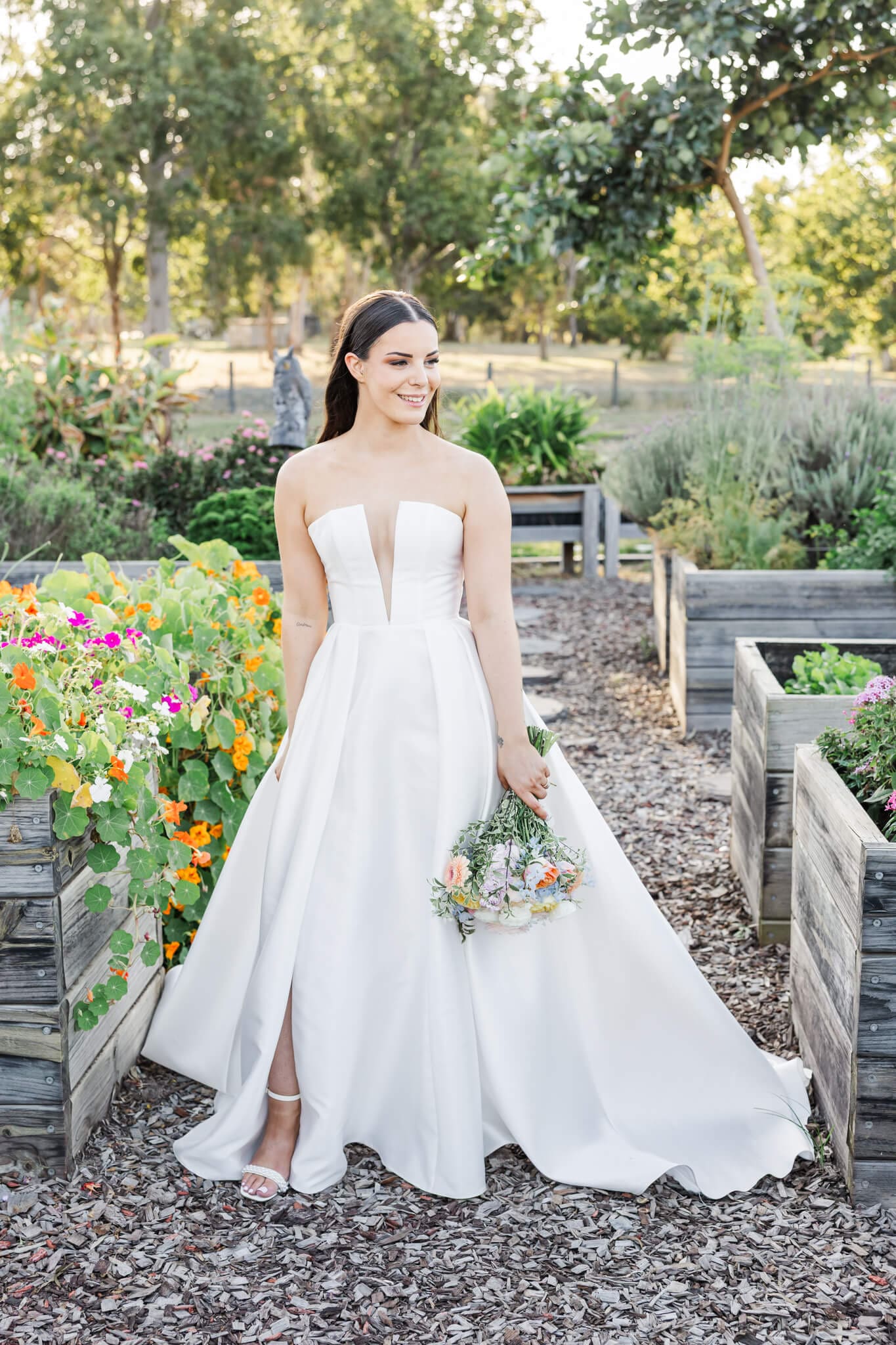 Bridal Portrait pf a bride holding her flowers in amongst gardens planted in large wooden crates.