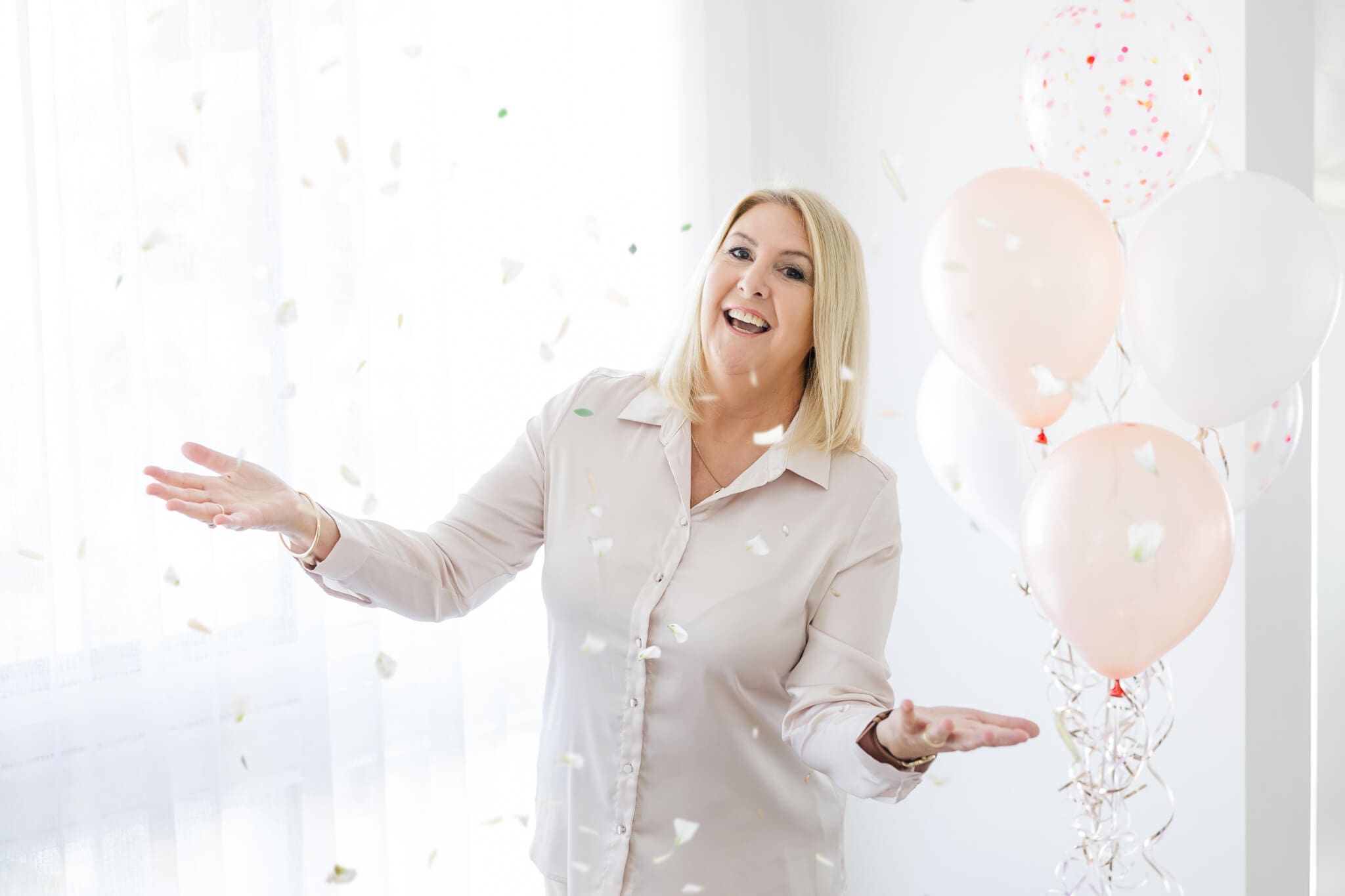 Beautiful branding photo for a marriage celebrant Ceremonies by Serena, catching falling confetti with balloons in the background.