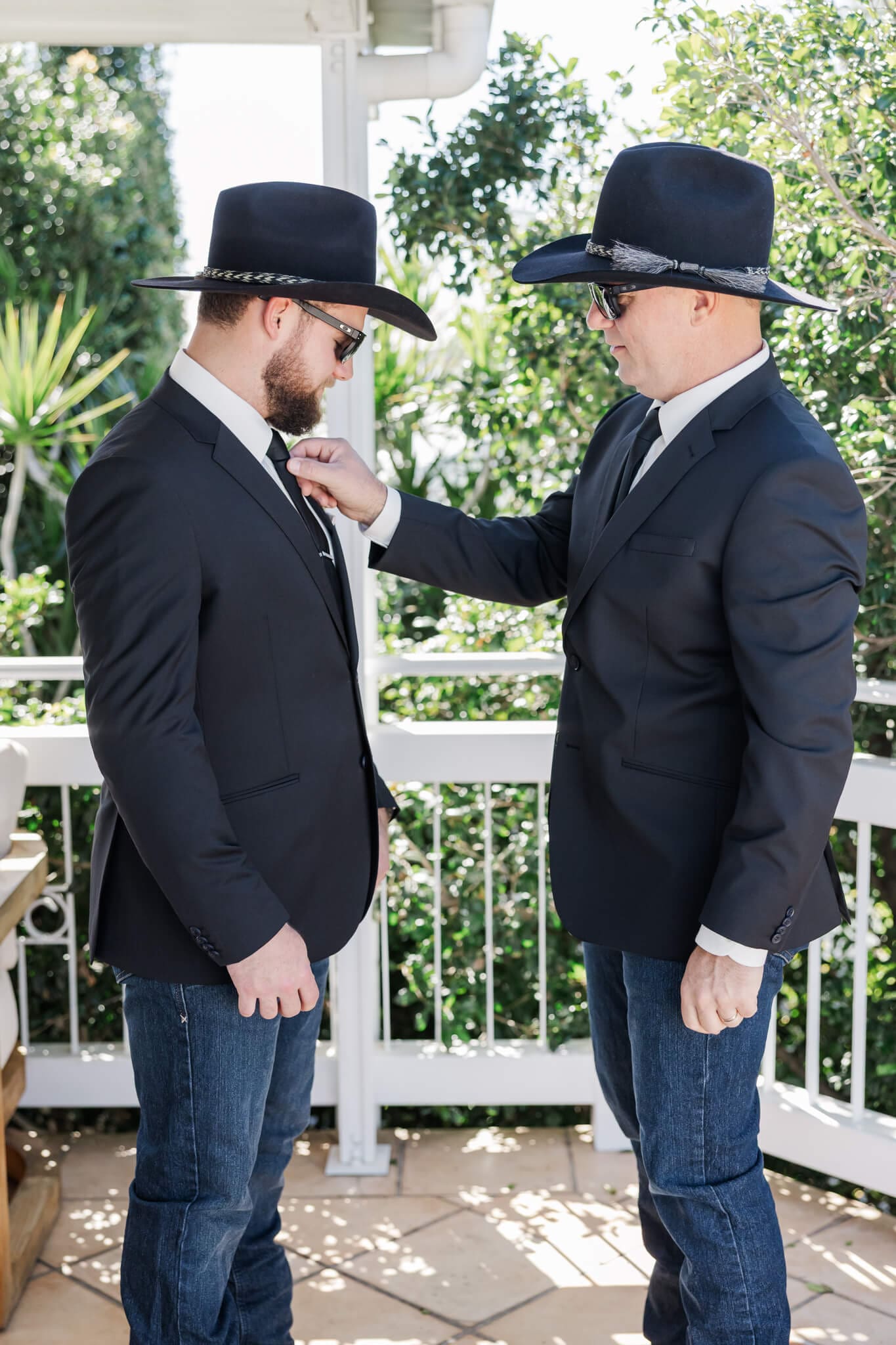 Groom's dad fixes his sons tie ahead of his wedding ceremony, as they are getting ready.