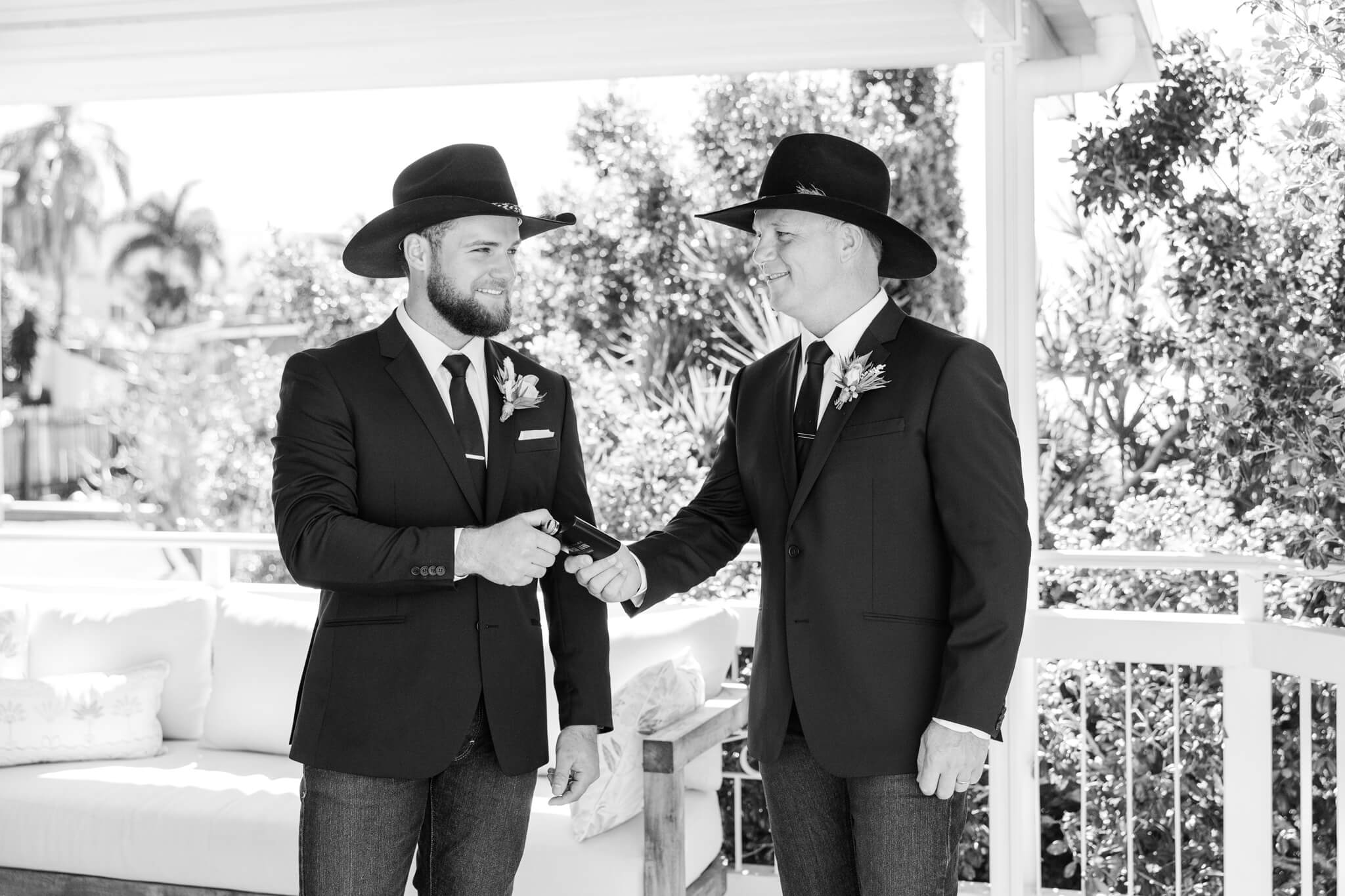 Groom accepts a  flask of whiskey off his dad before his wedding ceremony.