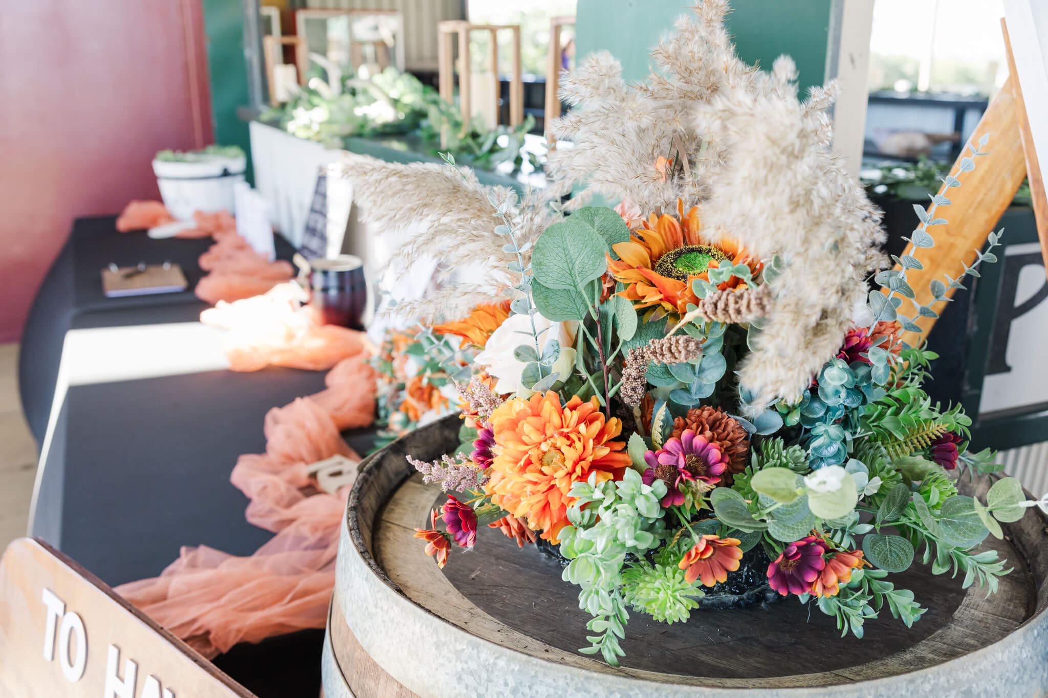 Beautiful bunch of florals decorating a wedding venue. Colours of orange, pink, creams and greens.
