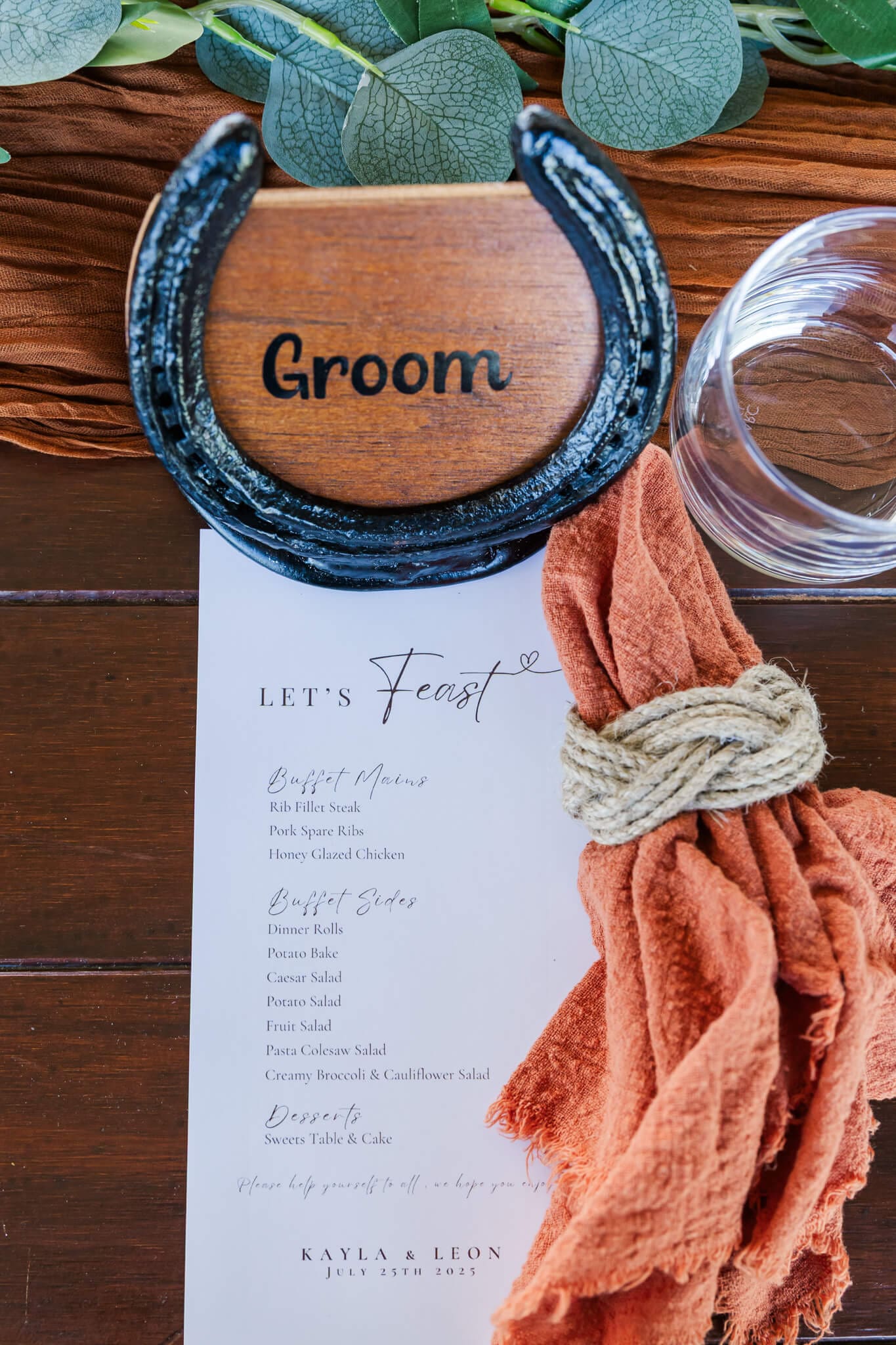Bridal table setting with an orange napkin and a stylish menu card next to it.