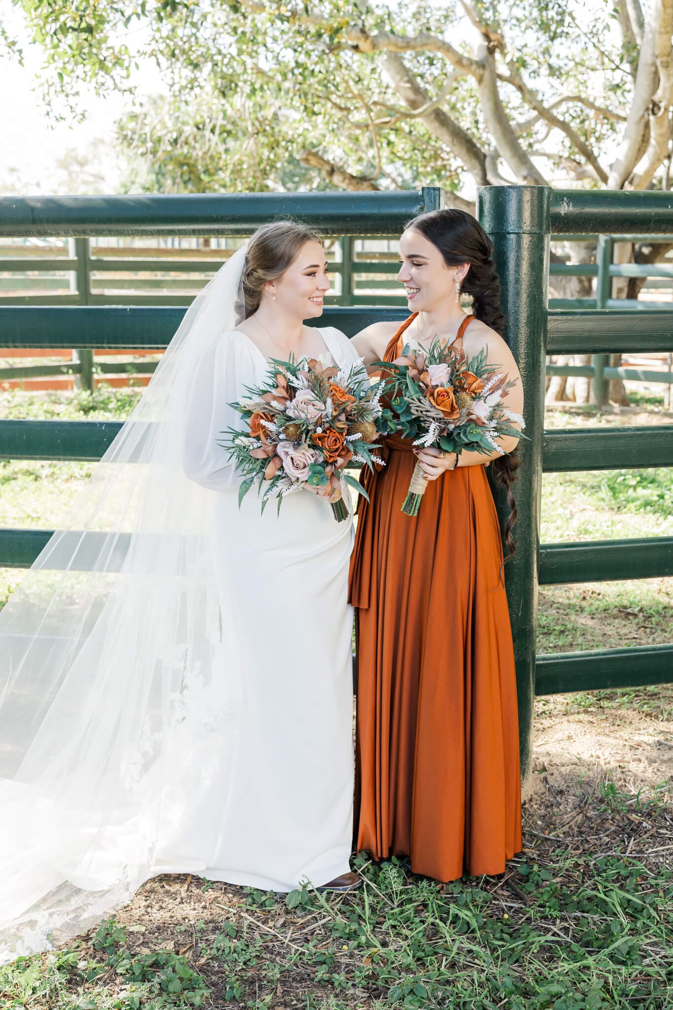 Bride and bridesmaid share a happy glance with each other during portrait time.