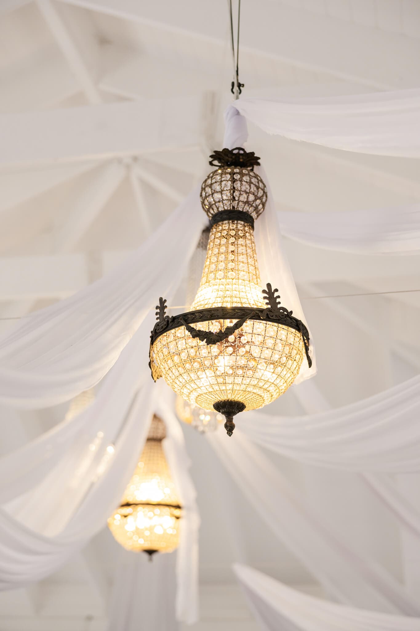 Luxury wedding reception details shots of a large chandelier at Ambrym Estate, decorated to achieve editorial wedding photography.