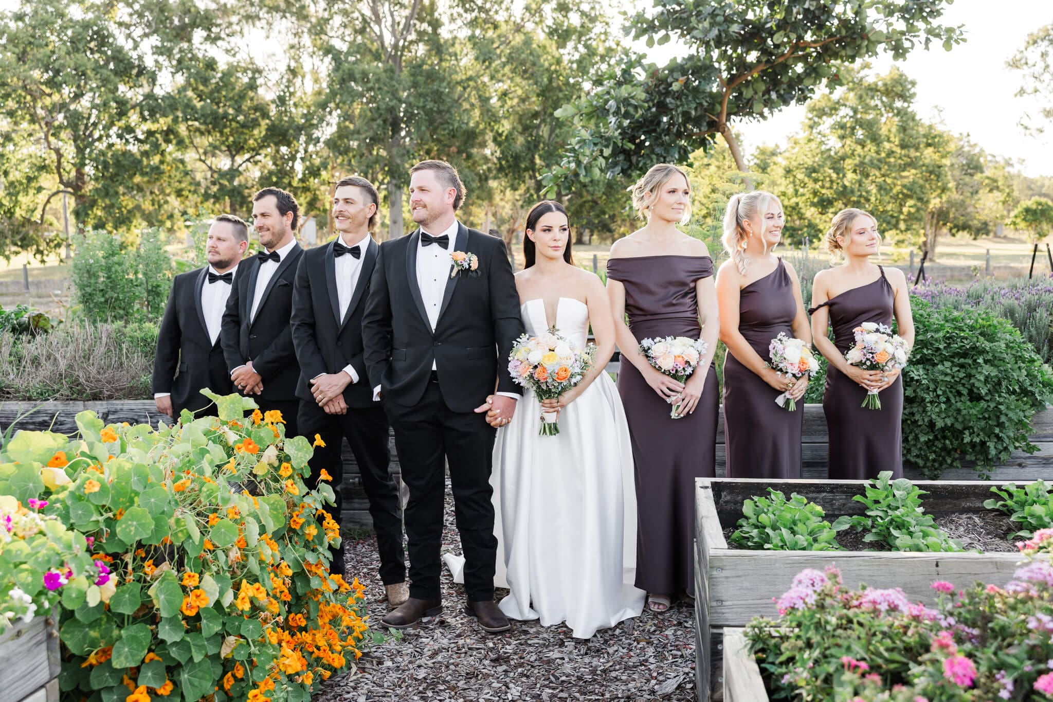 A gorgeous editorial wedding photography bridal party, standing in a v shape, looking in opposite directions into the distance.