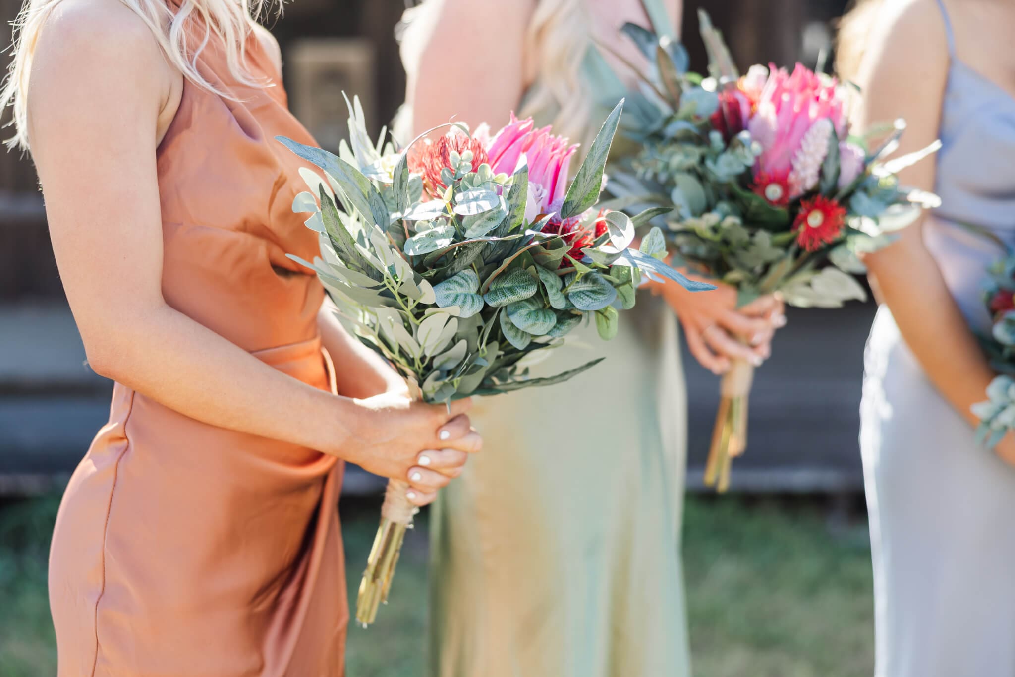 Beautiful native flowers in bridesmaids bouquets, consisting of pink, red and green colours.